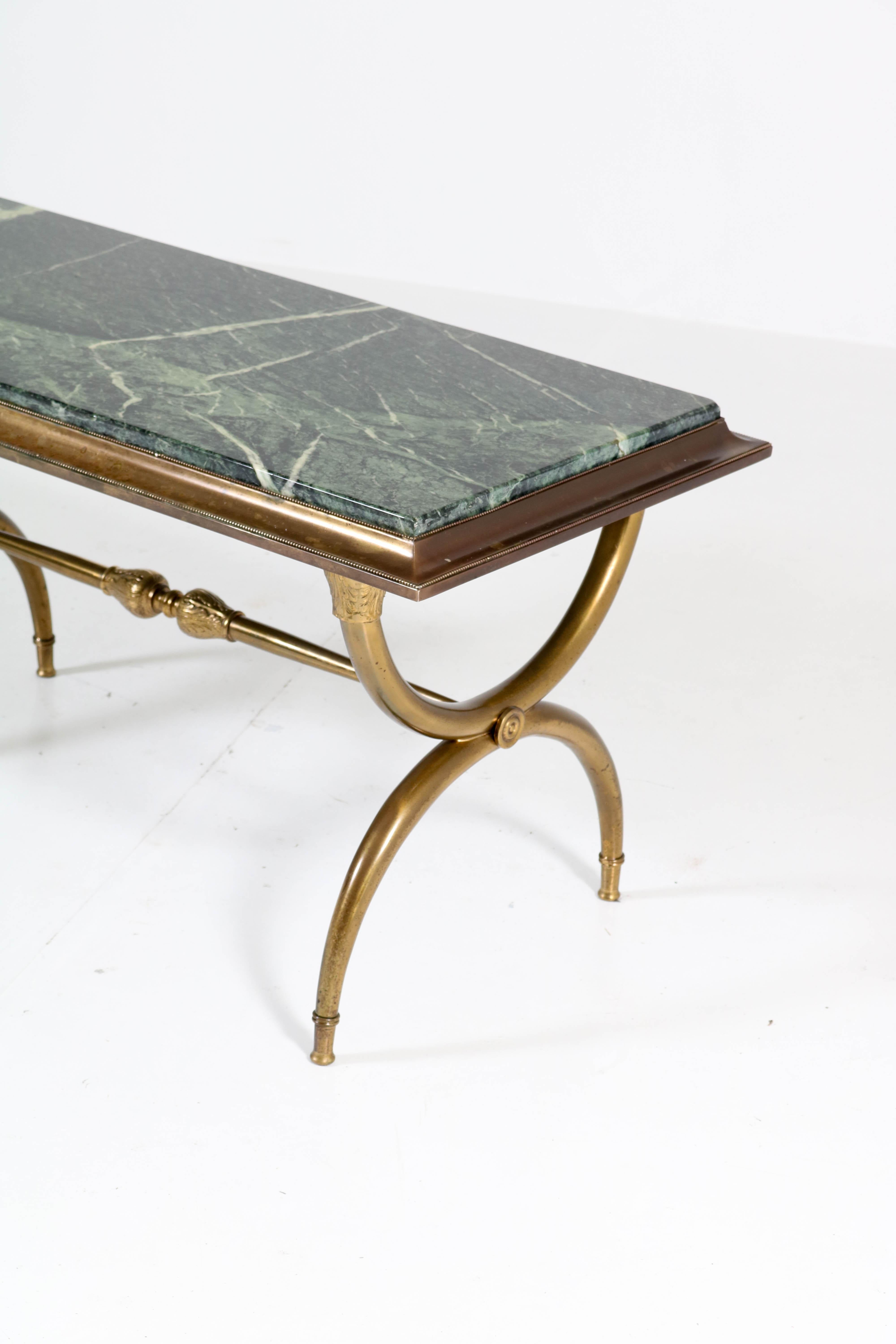 Stunning and rare Hollywood Regency coffee table.
In the style of Maison Baguès.
Striking French design from the 1940s.
Brass base with original Patricia green marble top.
In good original condition with minor wear consistent with age and