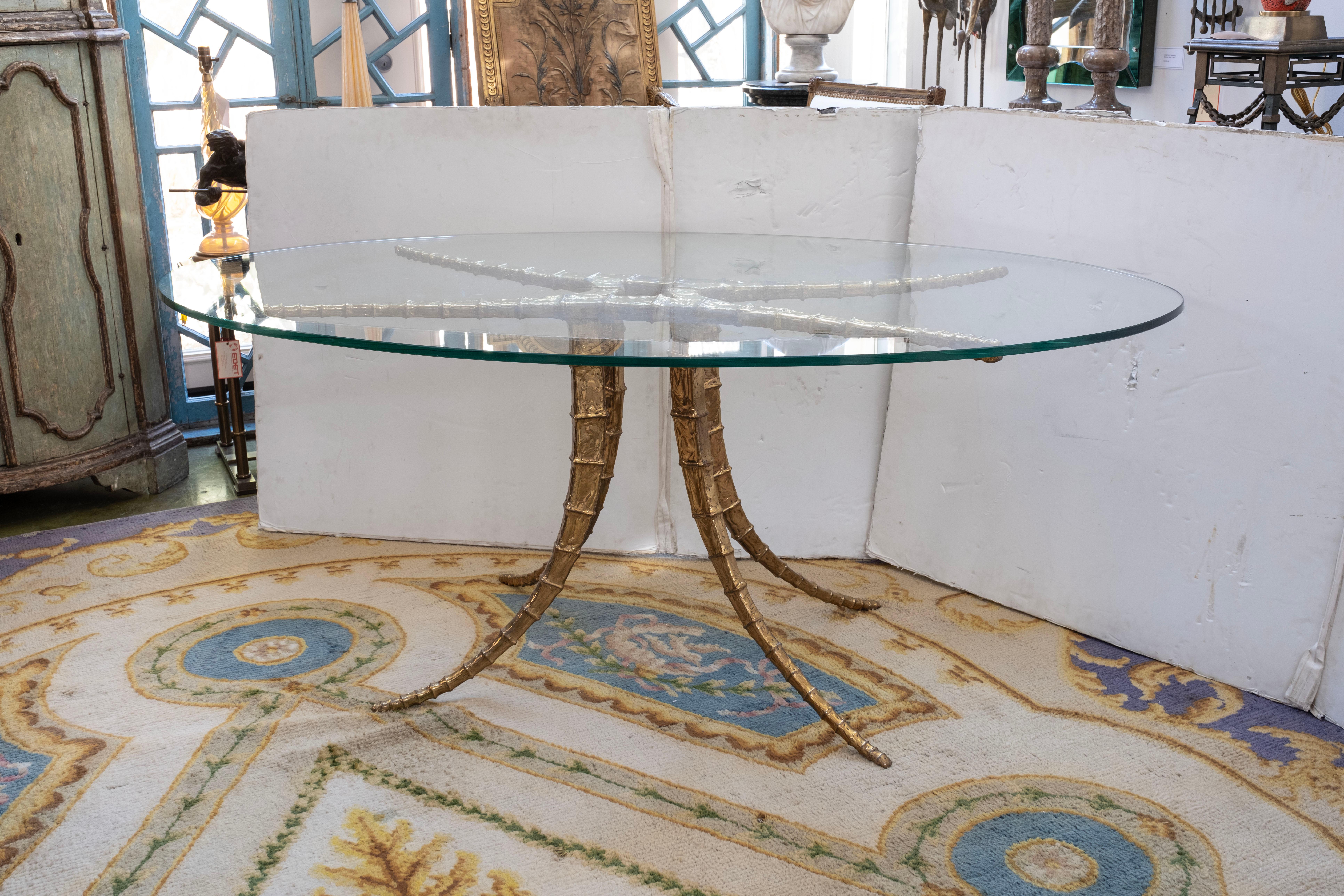 French brass horn dining table / center table signed by Alain Chervet.
This rare French brass horn table with an oval glass top is signed by Alain Chervet, 1981. Our versatile French Hollywood Regency table can be used as a dining table, center