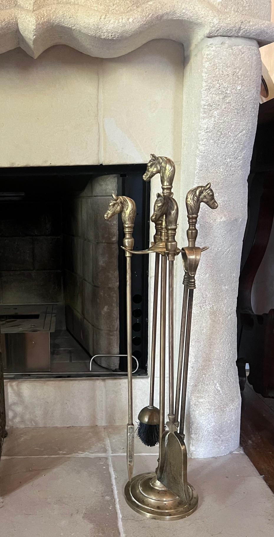 Mid century French brass fireplace set. with the shape of horse heads.  The set includes the stand, a brush, poker, tongs, and a shove. Some tarnish spotting mostly on the base. 