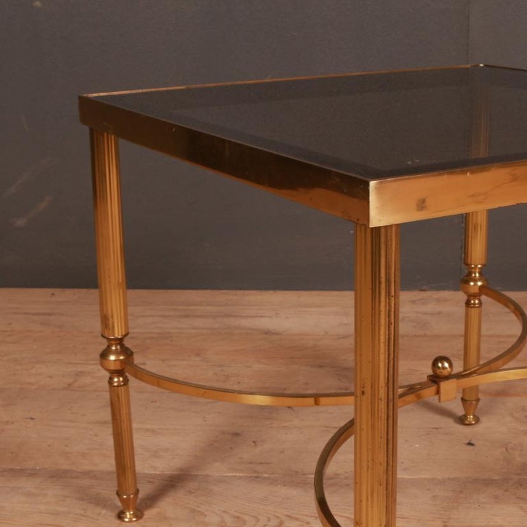 1950s French brass and glass lamp table with a shaped stretcher, 1950.

Dimensions
18 inches (46 cms) wide
18 inches (46 cms) deep
16 inches (41 cms) high.

     