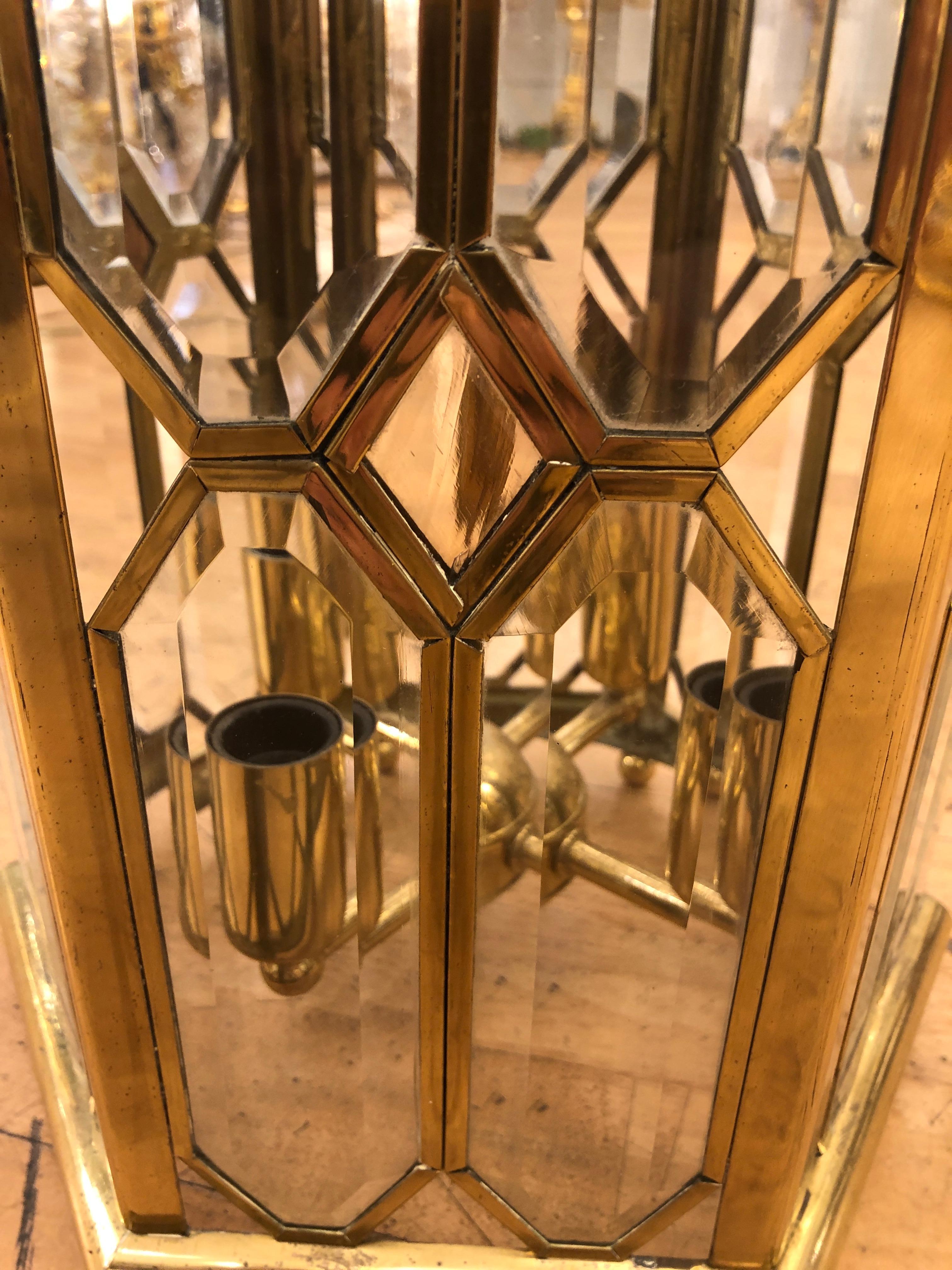 A beautiful brass and glazed lantern. Part of a set of three matching lanterns. NOW ONLY TWO AVAILABLE AS ONE SOLD. Price is for one lantern only. The six sided lantern features 4 glass panels in each face with a diamond central panel and open