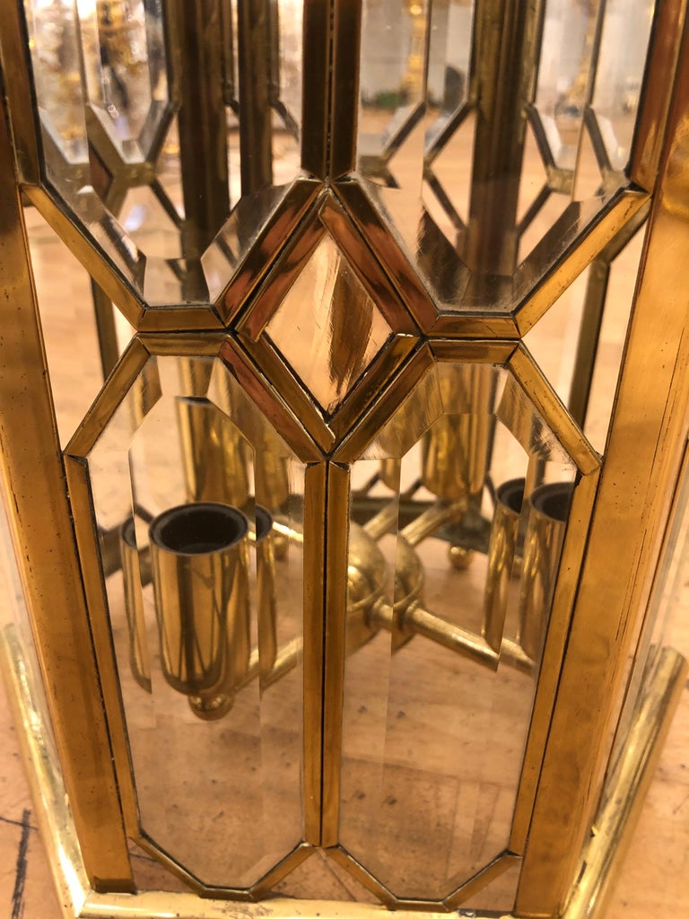 A beautiful brass and glazed lantern. Part of a set of three matching lanterns. Price is for one lantern only. The six sided lantern features 4 glass panels in each face with a diamond central panel and open triangular corners, base, top and side