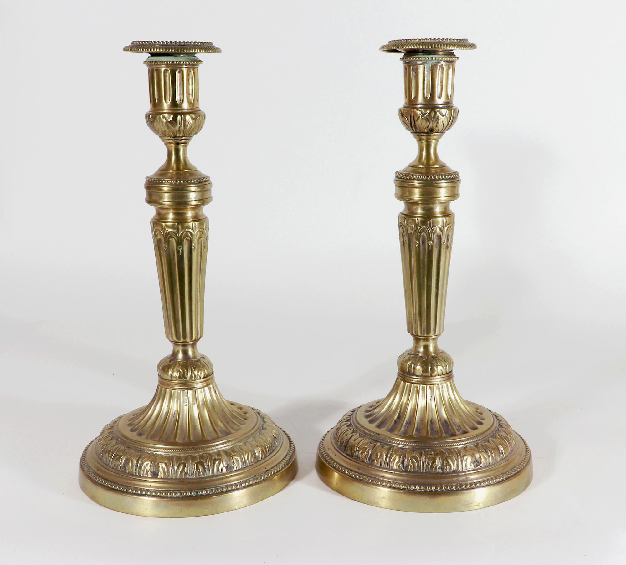 Stylish French Brass Candlesticks,
Circa 1780

The large French brass candlesticks are of circular form each with a hollow base and fluted column.  Each with a detachable nozzle.  The candlesticks have a good heavy weight.  The hollow foot is flared
