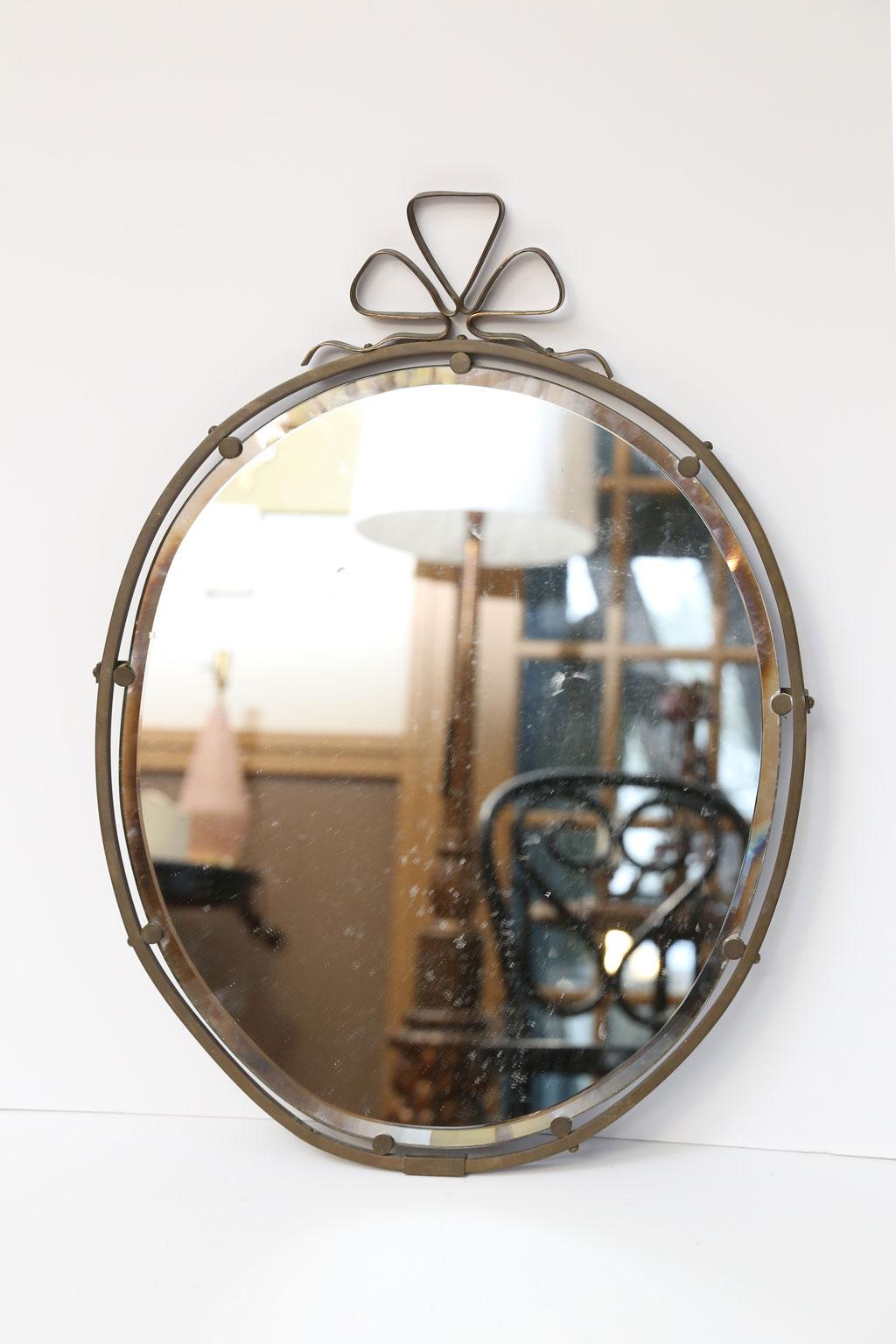 French brass ribbon motif mirror from the 1930s-1940s. The mirror is all original including the beveled glass. 