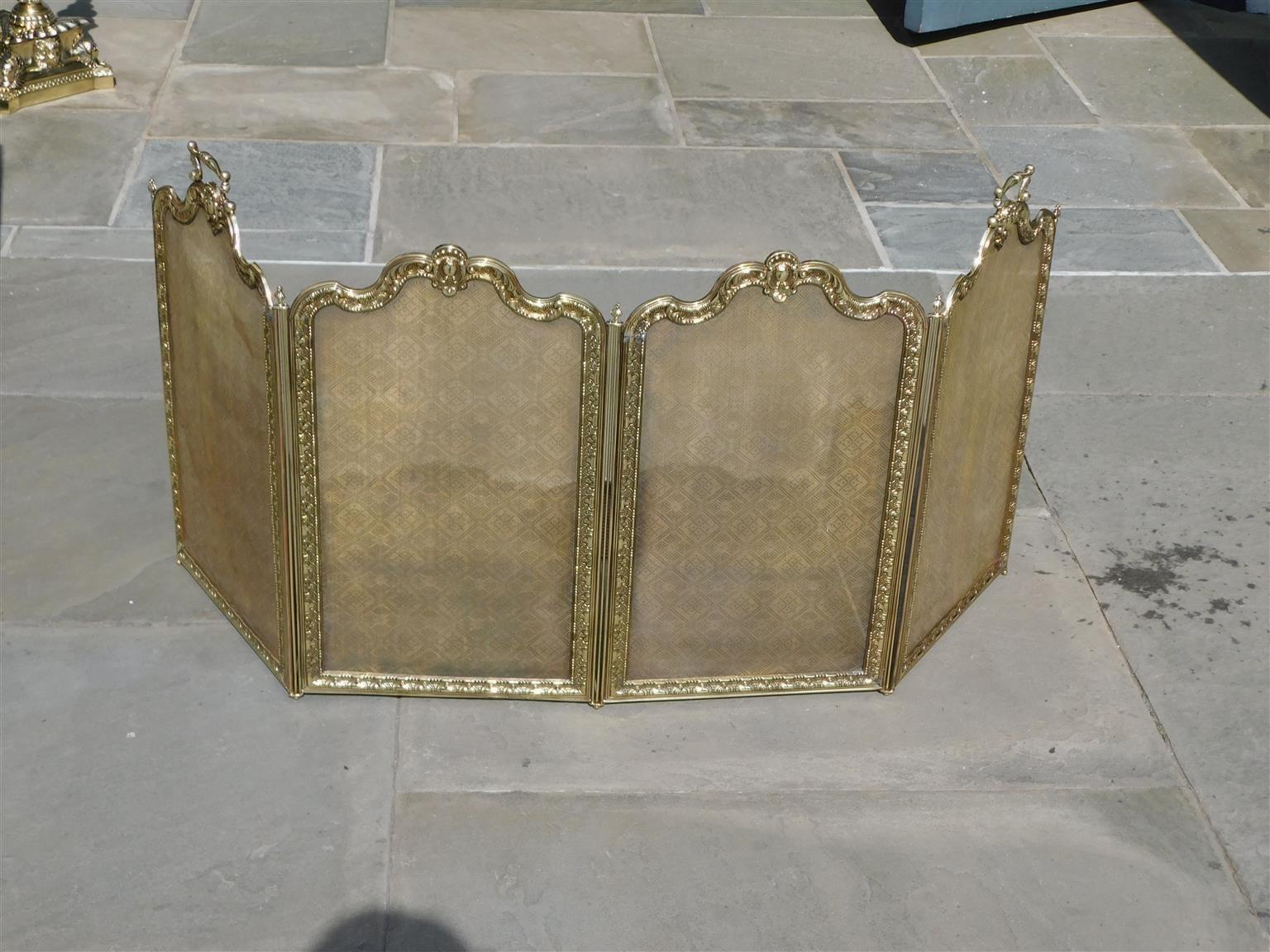 French Brass serpentine four panel folding fire place screen with decorative beaded foliage medallions, engraved ball finials, and flanking side handles. Early 19th century.