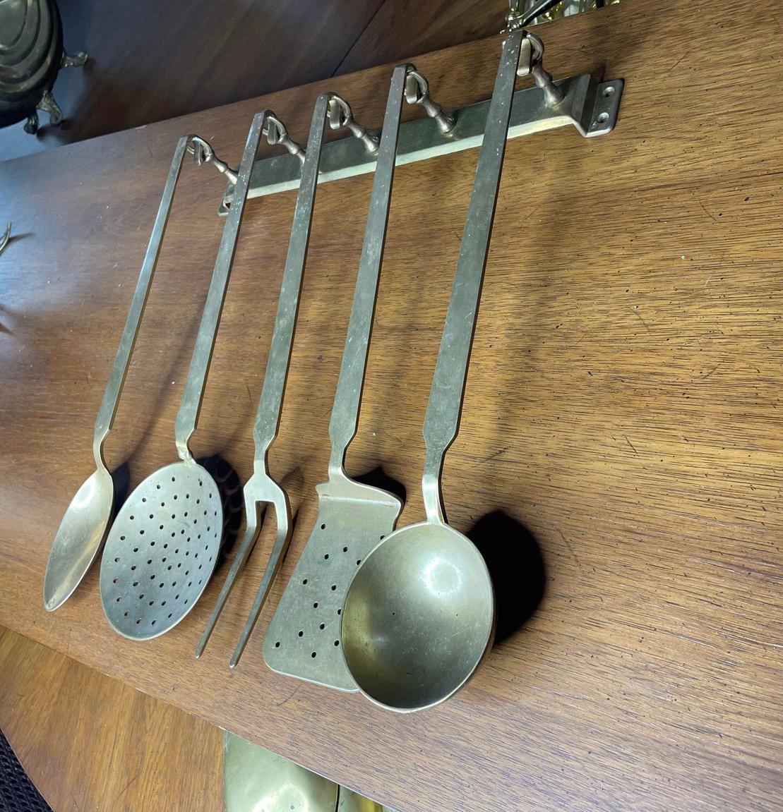 A set of solid brass serving utensils perfect to decorate your kitchen walls with taste! (Pun intended.) Included are five large solid brass serving utensils and the original hanging bar, so six pieces total. You might have come across a similar set