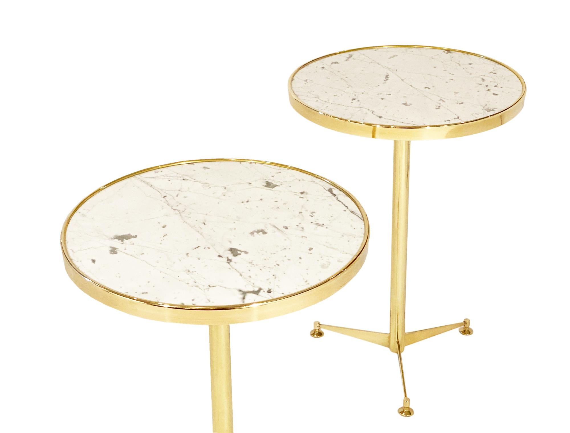 French brass side tables with onyx marble tops. The gilt brass bases have tripod feet.