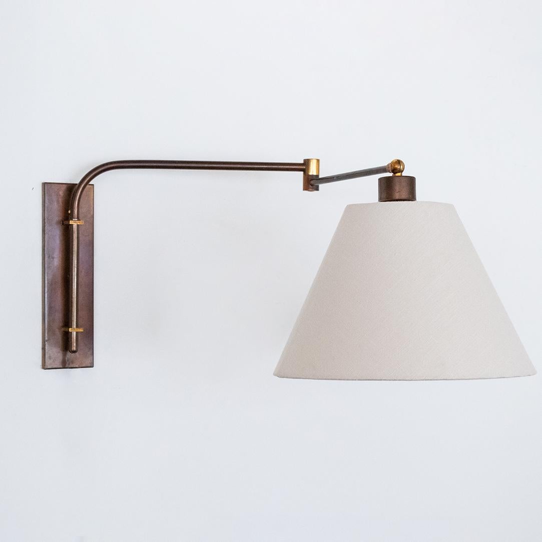 French wall mounted brass swing-arm extendable sconce with new creamy linen shade. Newly re-wired with plug and hand-switch on cord. 

Fully extended length is 33