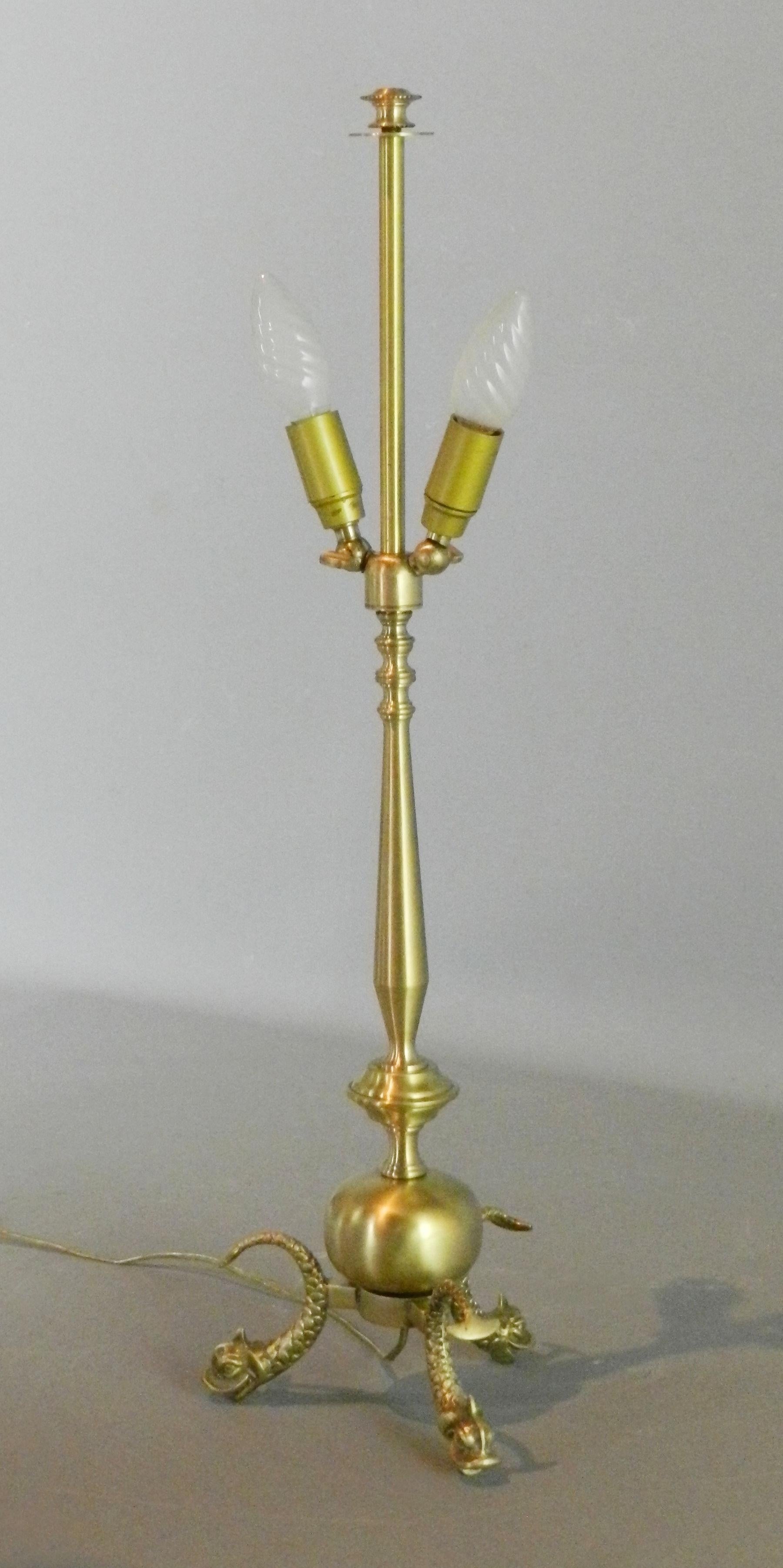 A distinctive French brass table lamp with Serpent Feet of good proportions depicting three serpents as feet attached to a bulbous central stem leading up to adjustable candle bulb light fittings.

The gold electric cable is fitted with an in-line