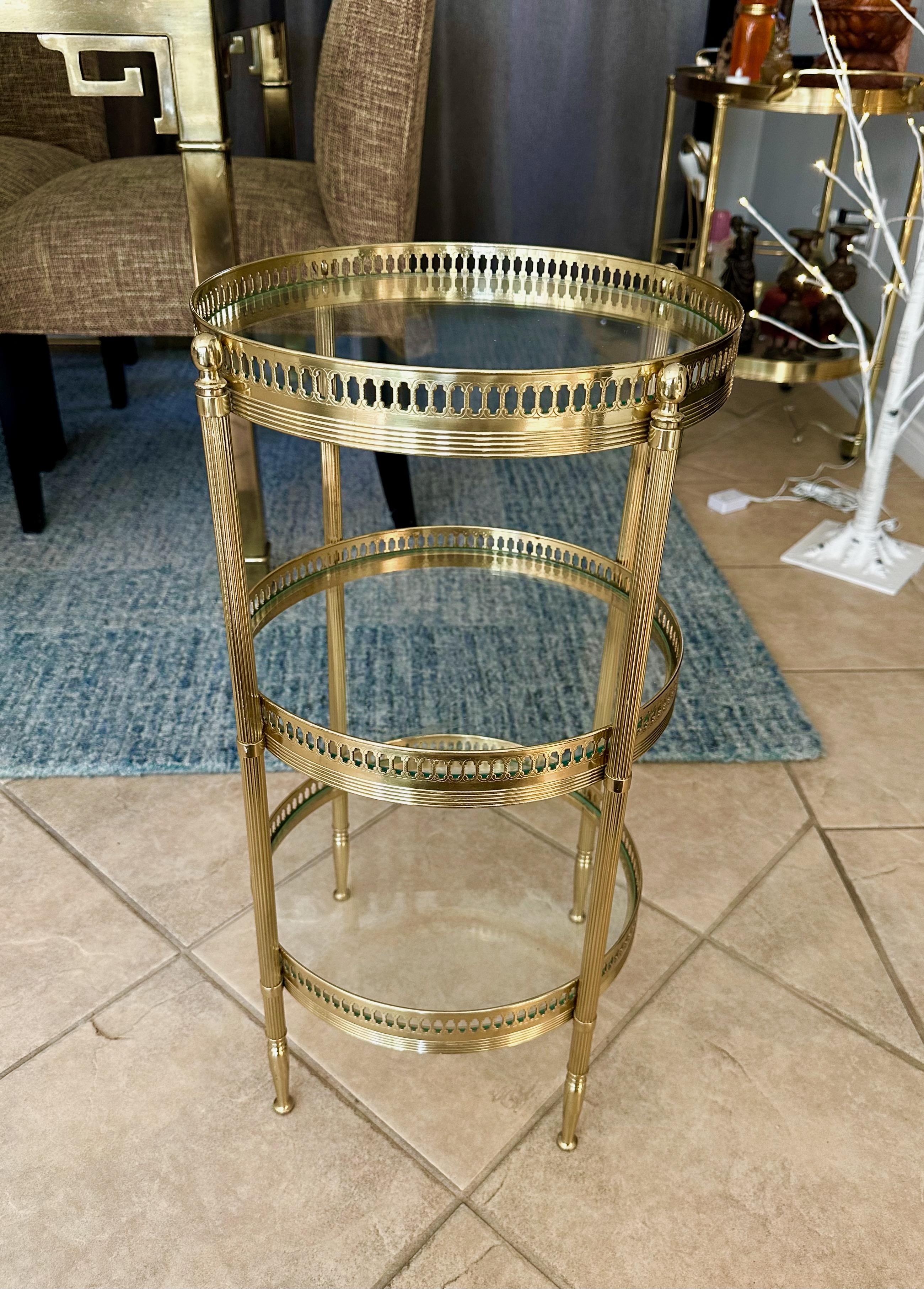 French smaller scale round three-tier brass side or end table with glass shelf insets. Nice detailing including reeded legs and pierced gallery railing on each shelf. 