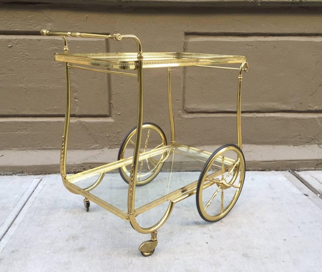 French brass two-tier bar cart with glass shelves.
 