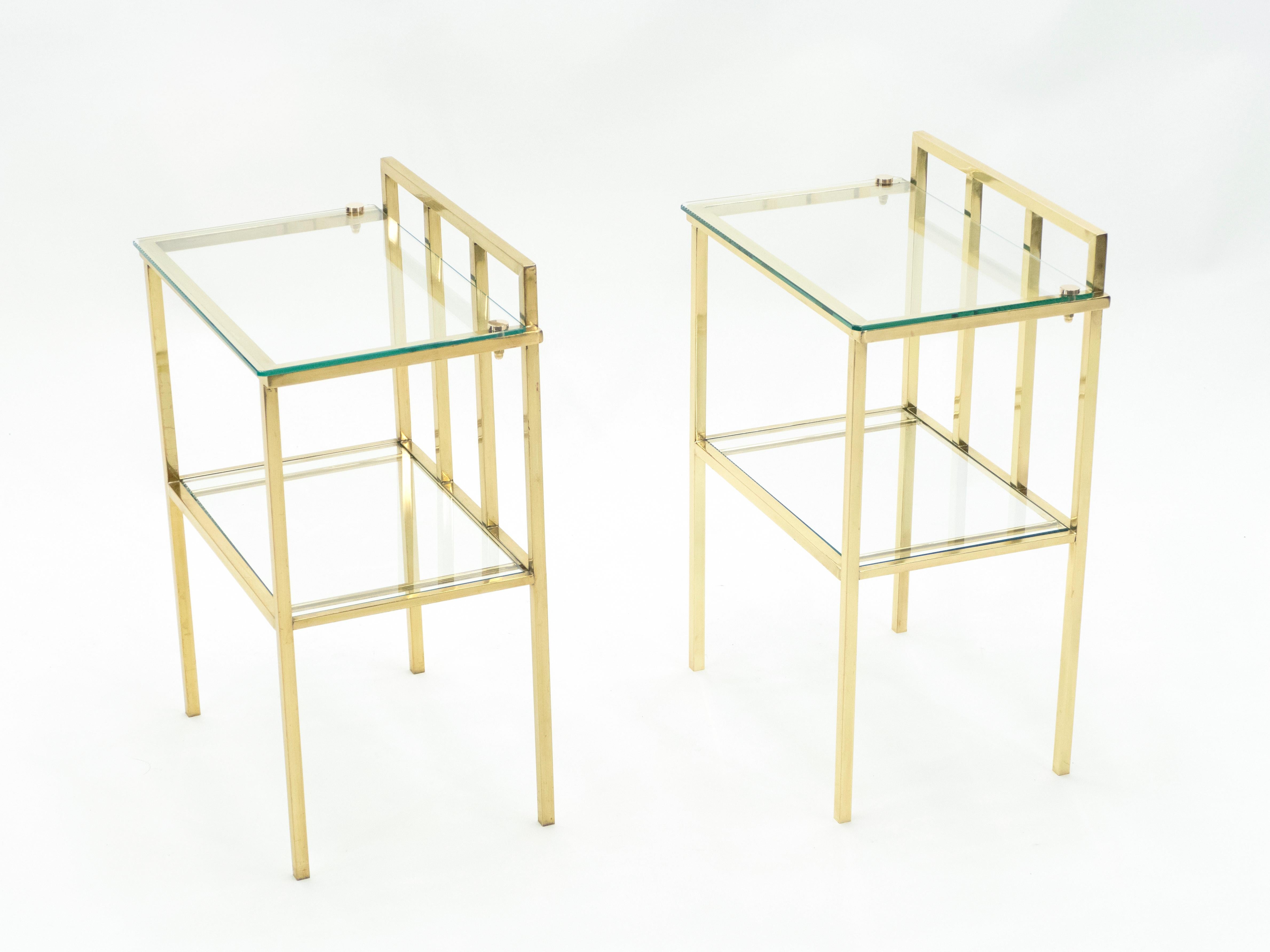 Simple lines point to these two-tier end tables French midcentury roots. Designed and produced in France in the early 1960s, probably by Marc du Plantier, it features silky brass legs and structure with glass tops. Its symmetry, elevated glass, and