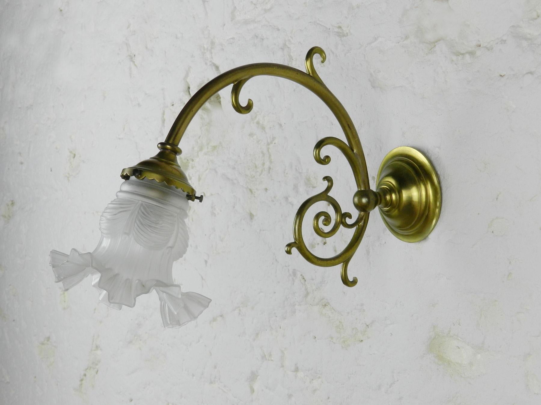 A French solid brass wall light with an attractively curled lamp support terminating in a pretty ribbon decorated glass shade / tulip. 

This light has been tested and is in full working order. As with all electric items we recommend that it is