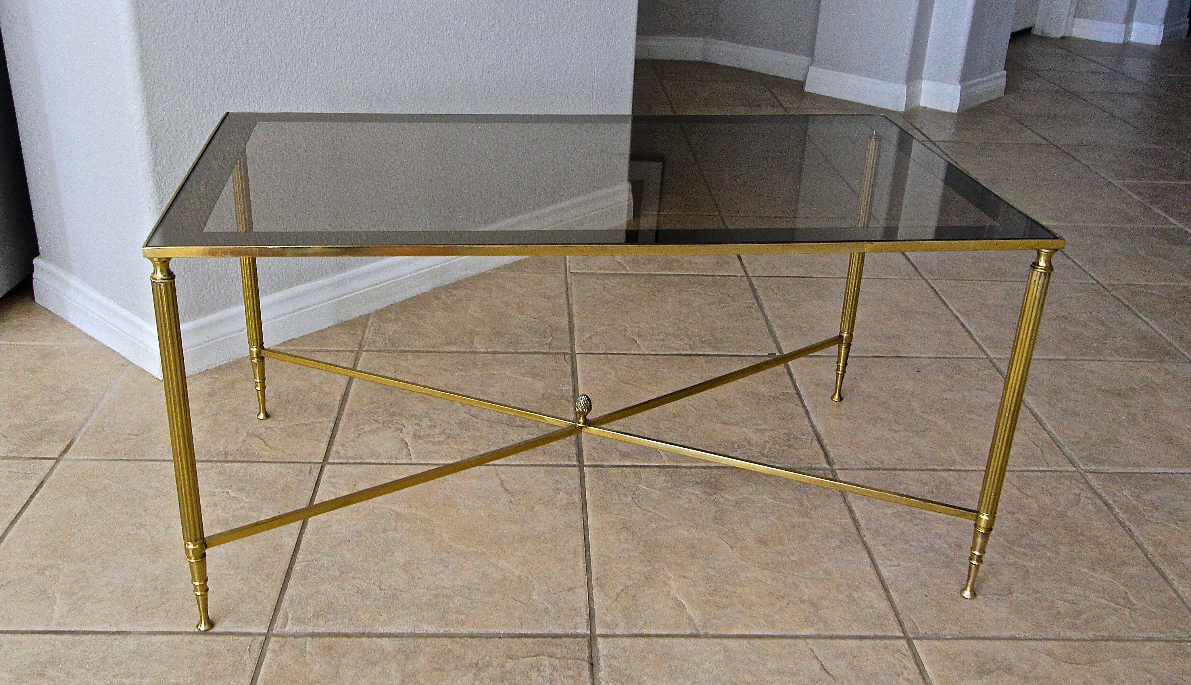 French brass X base coffee or cocktail table with inset tinted mirror edge top. Nicely detailed with reeded legs, X stretcher and acorn center finial.