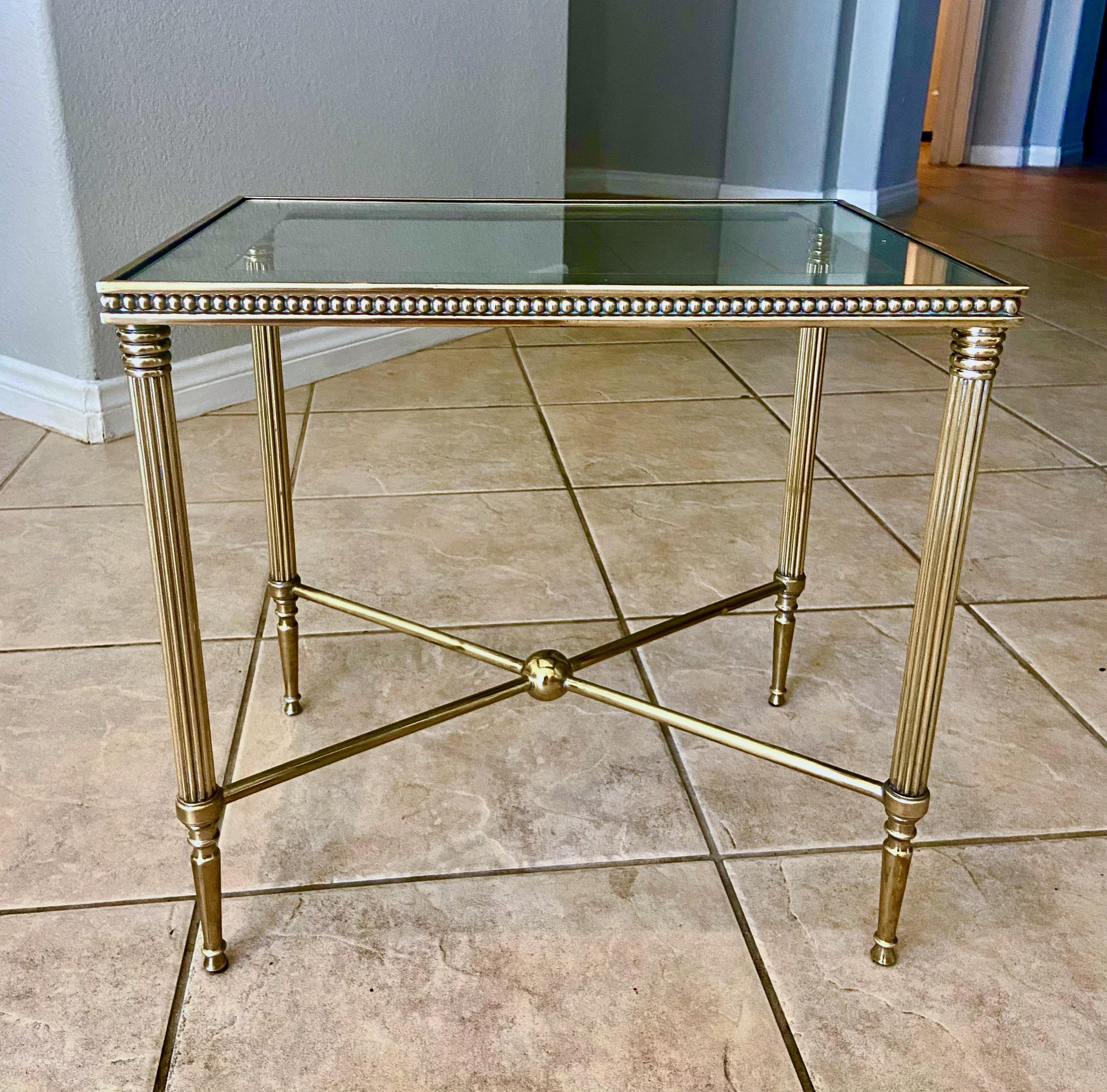 Smaller scale brass side table with x-base stretcher, reeded legs and mirrored edge inset top.