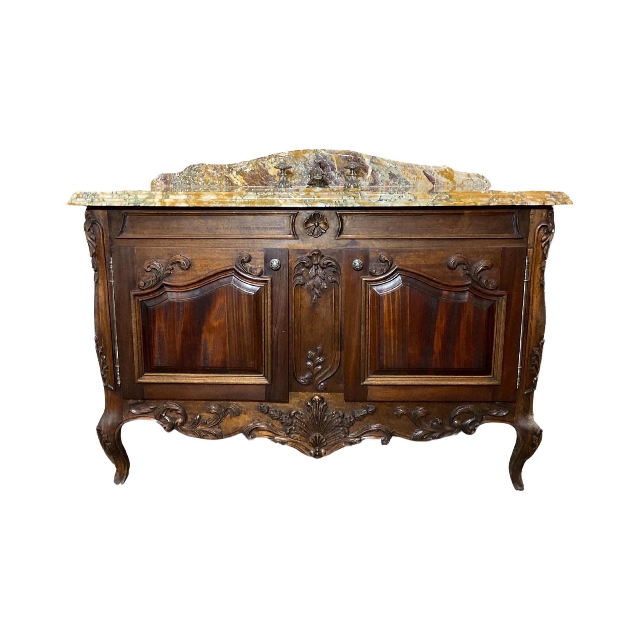 This 19th century French sink is made of Breche de Benou Jaune marble on top and walnut wood on the bottom for the base of the sink, accented with Louis XVI-style carvings. It also features two opening doors for under-sink storage and a Sherle