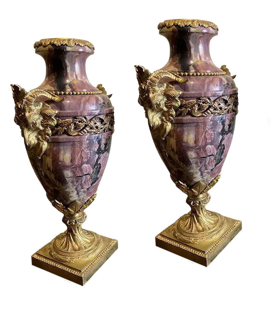 A pair of French Breche Violette marble urns with gilt rams heads and swags. Circa 1860.