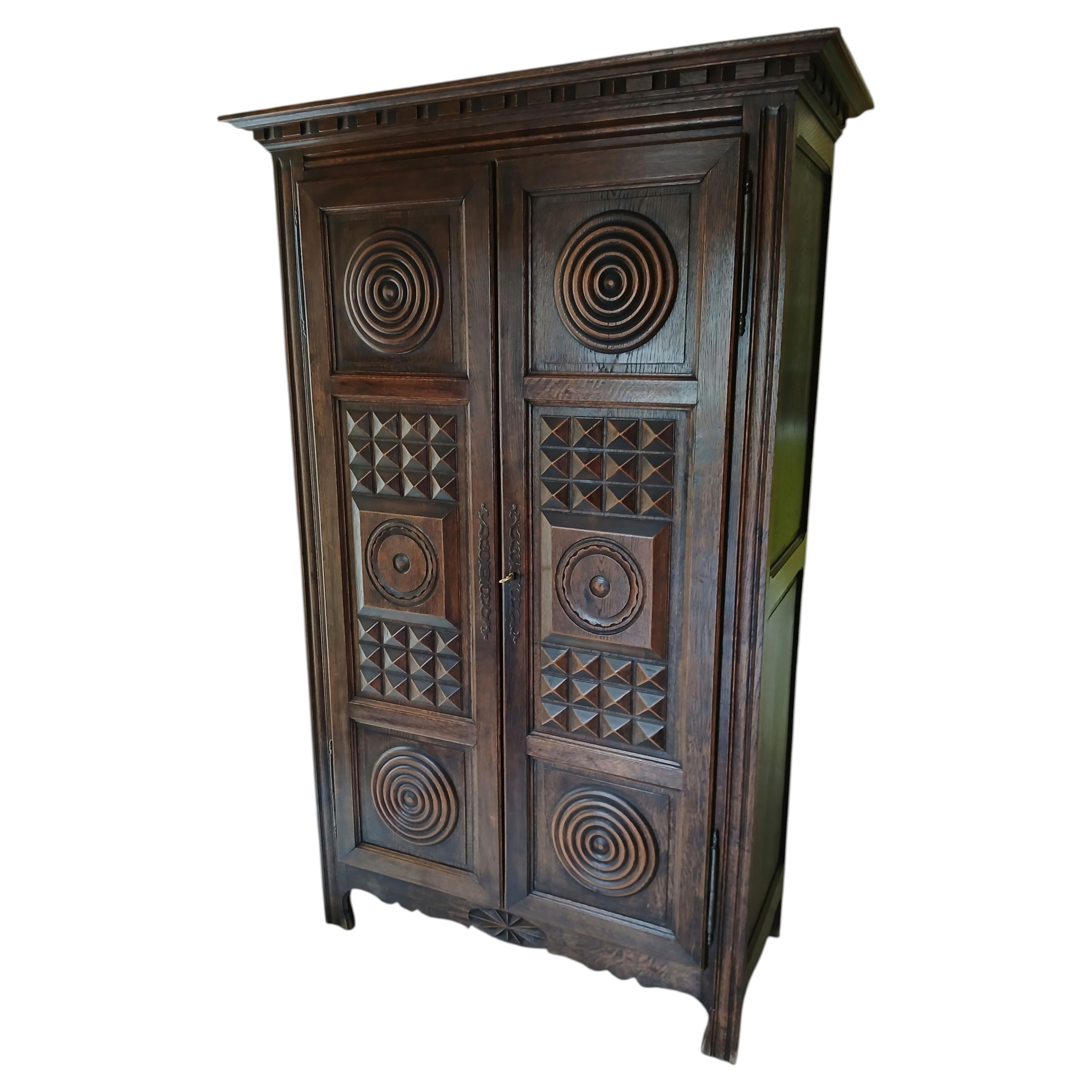 Armario francés de dos puertas de estilo bretón, de roble, con paneles geométricos tallados, década de 1940