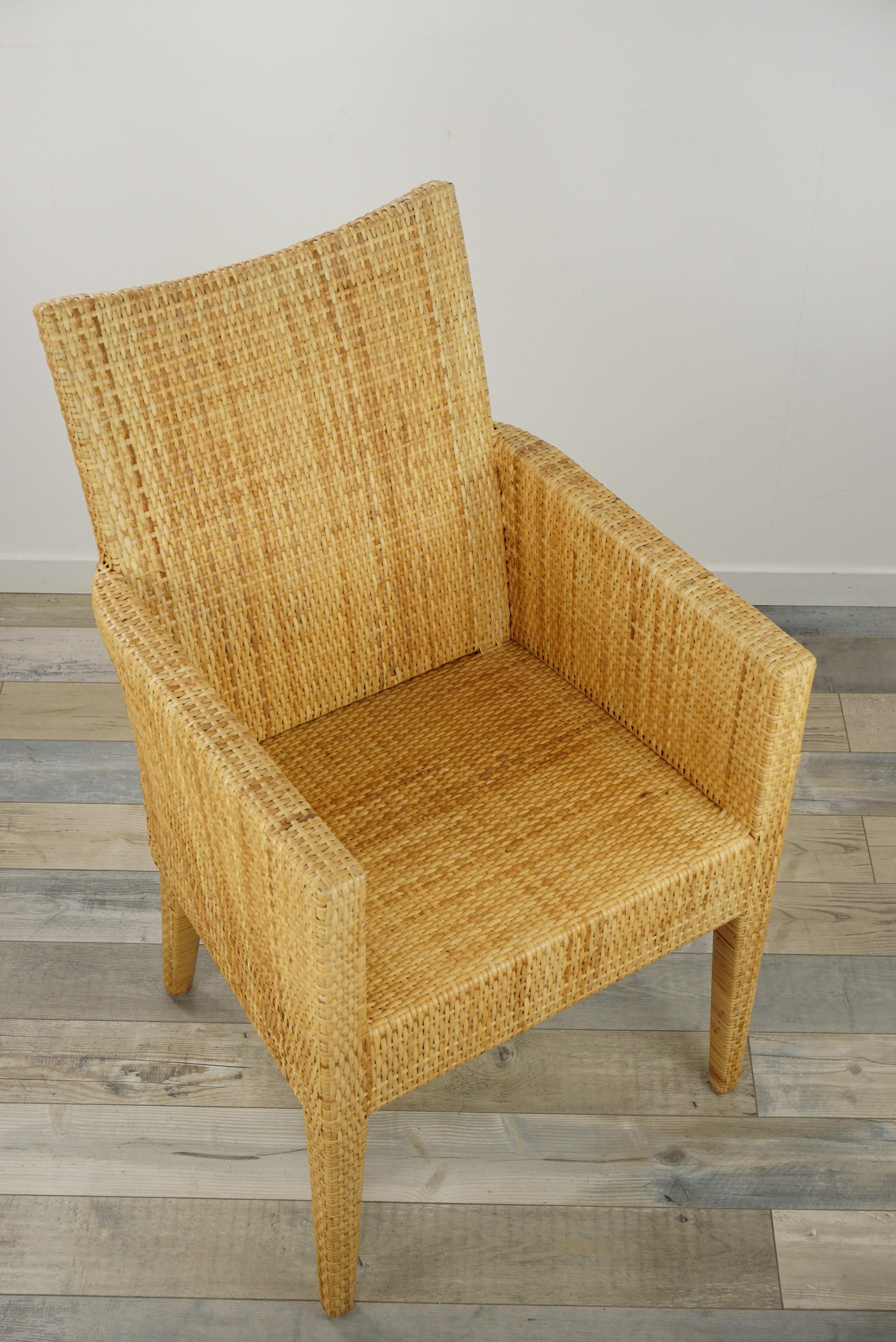Sculptural bridge armchair rattan with a structure in solid wood covered with a braiding of natural rattan blade.