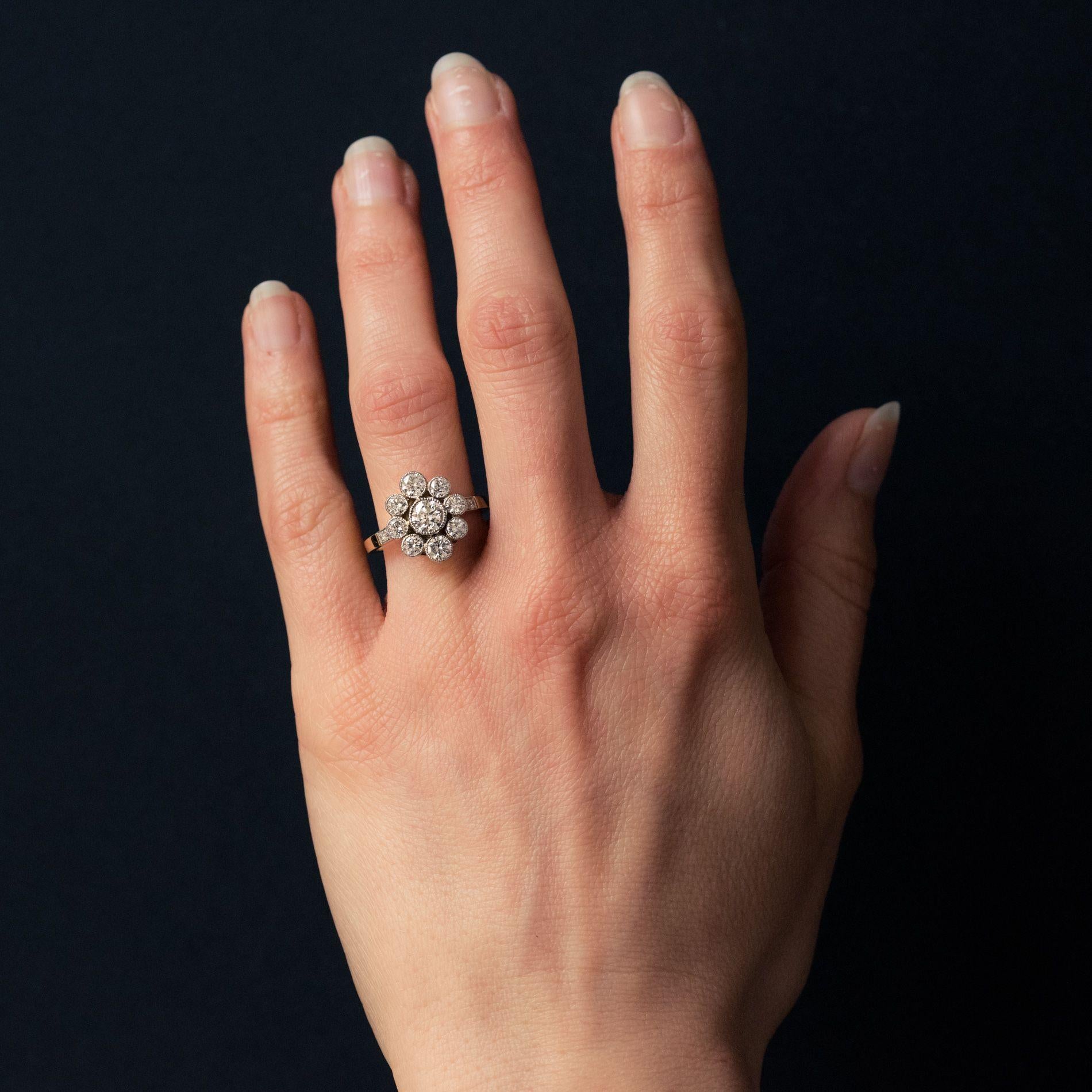 Ring in 18 karat yellow gold and platinum, eagle and dog hallmarks.
This beautiful ring is set with a central diamond surrounded by 8 other diamonds. Each side of this design, at the beginning of the band, is set with another 2 diamonds. 
Weight of