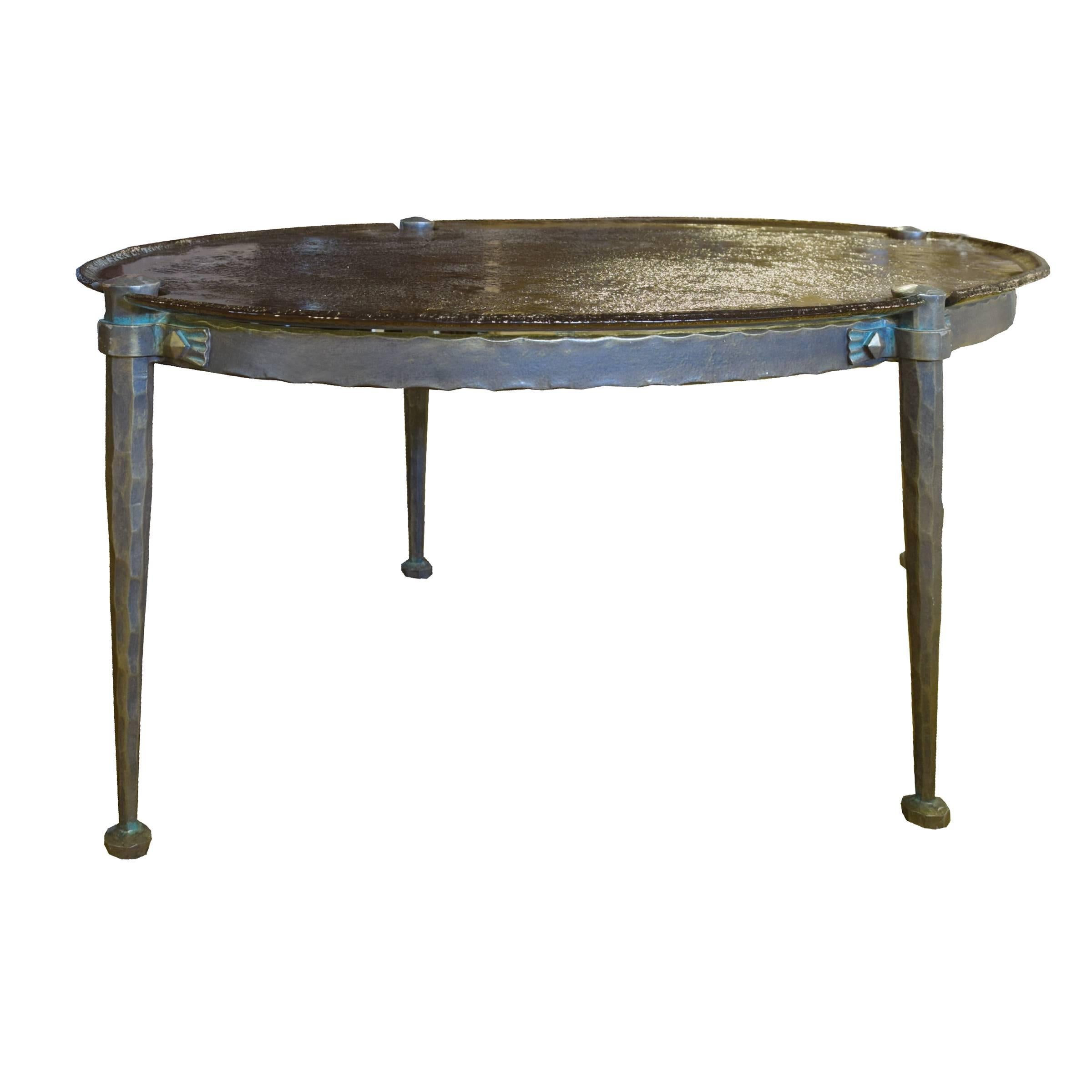An exceptional French midcentury cast bronze four-legged low table with a great patina and a textured and smoked cast glass top.
 
