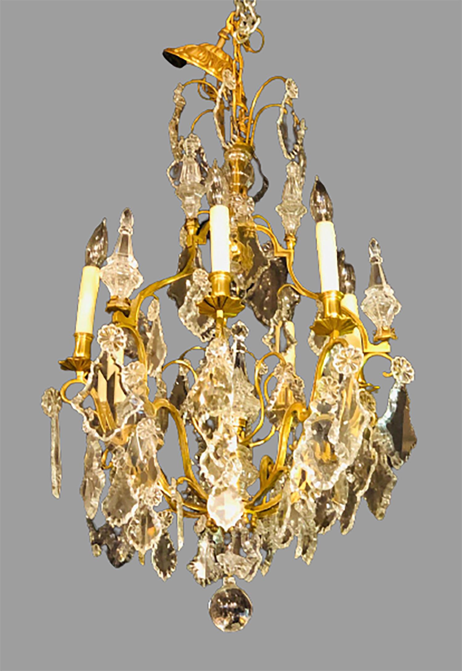 French bronze and crystal gilt chandelier. Louis XVI style six-light chandelier having a glass column-form center with brass arms supporting hanging large crystals flowing from the central form. Recently rewires this finely crafted chandelier is