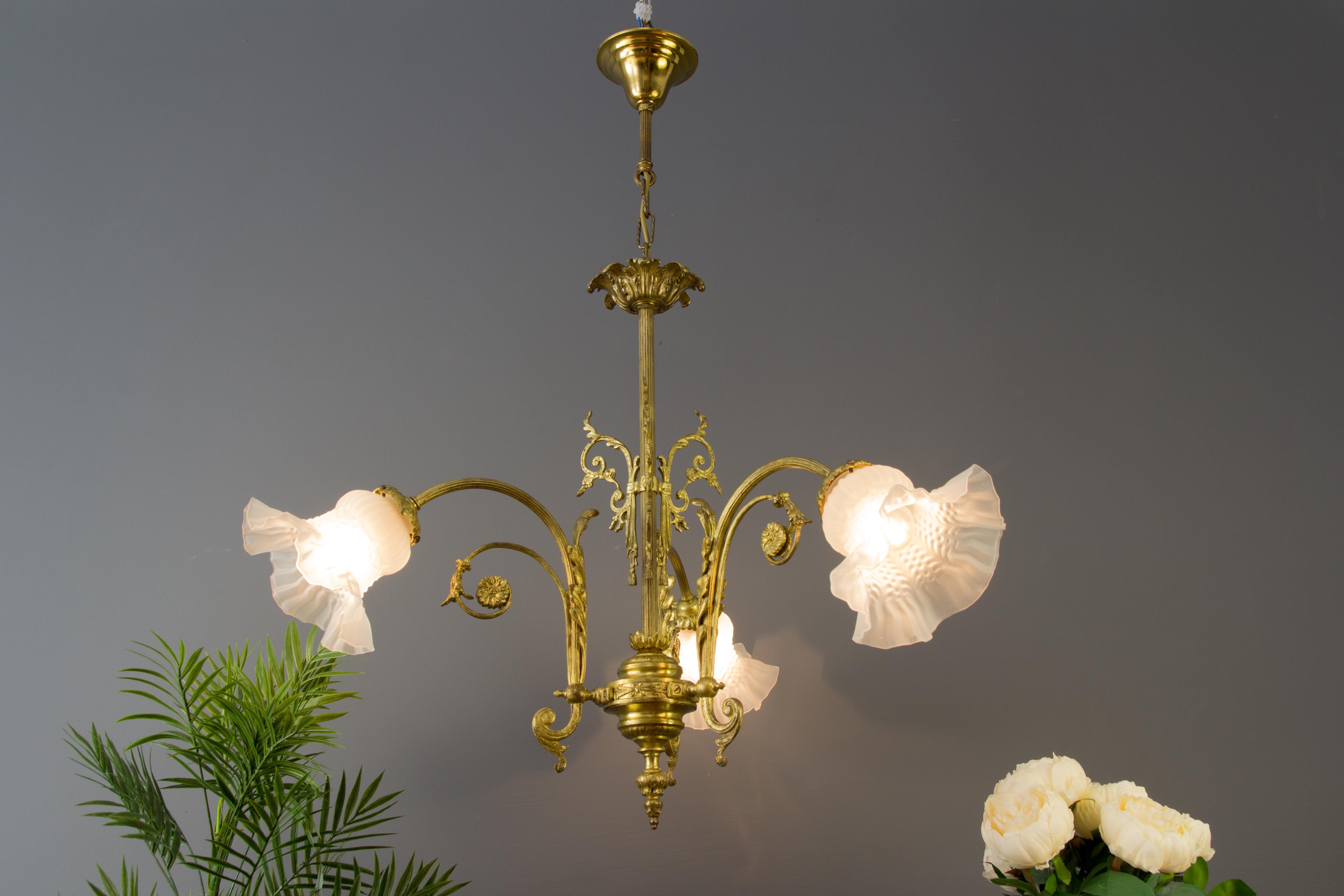 Lovely French Louis XVI style bronze and brass chandelier with three bronze arms each with frosted glass lamp shade and a socket for E27 light. France, 1920s.
Measures: Diameter: 80 cm / 31.49 in, diameter without glass shades: 50 cm / 19.68 in,