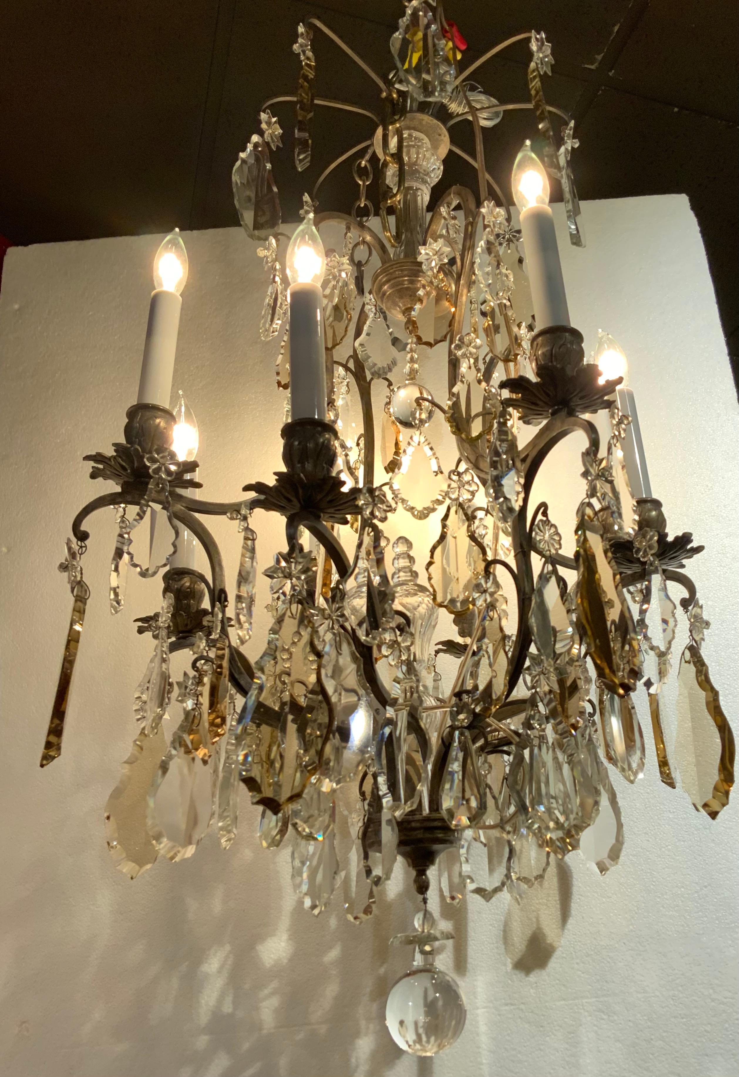 Fine French bronze and crystal chandelier in the Louis
XIV taste, the eight light chandelier with bronze argente
Frame, the central standard clad with molded glass, the scrolled
Candle arms terminating in leaf-molded candle cups and
Drip pans,