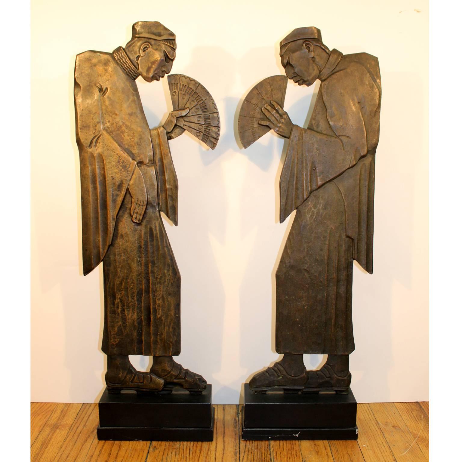 A pair of French Art Deco cast bronze sculptures of Chinese men holding fans. Dark bronze patina, unsigned. The pair was possibly part of the elements of a banister.