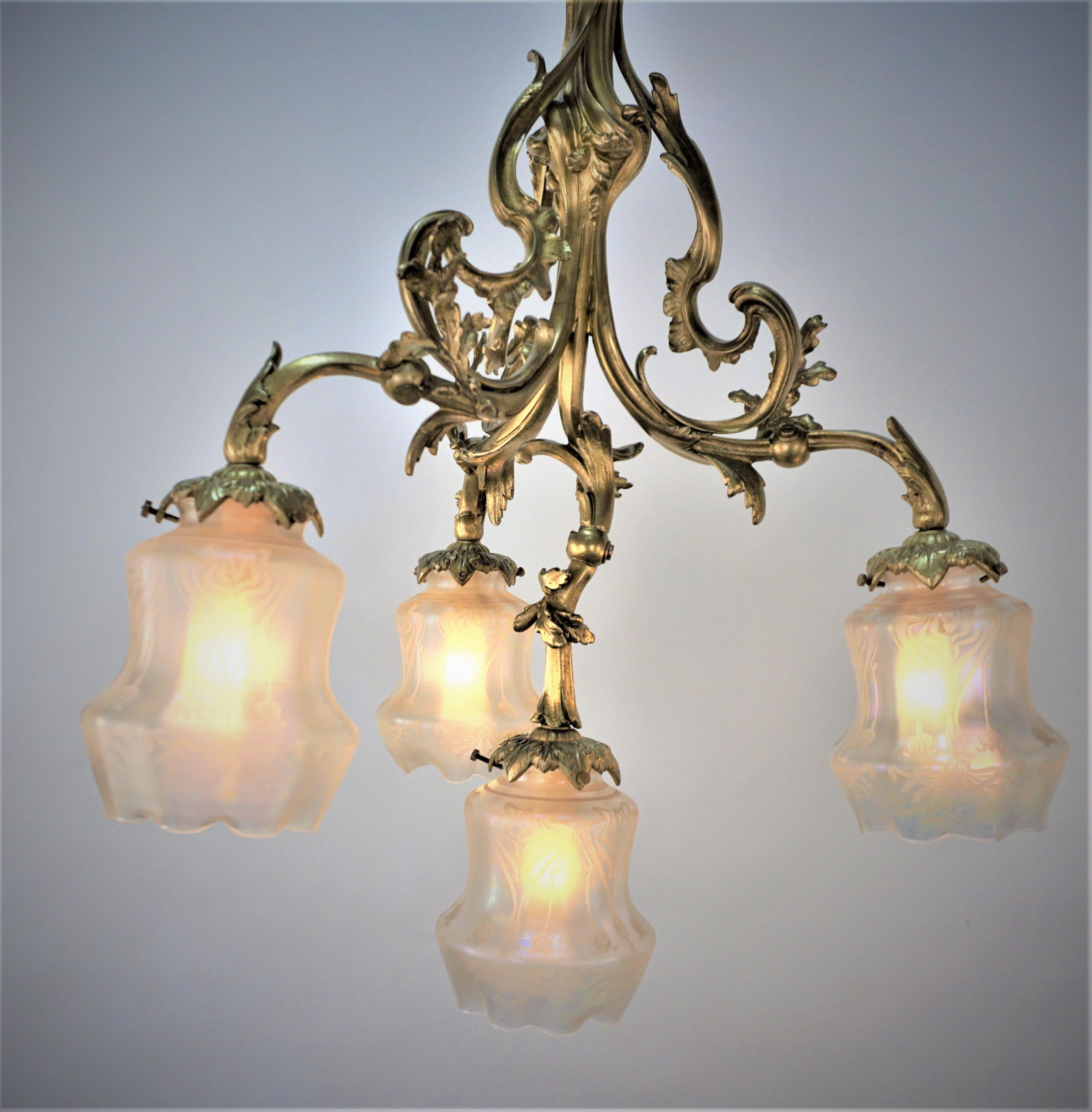 French Art Nouveau bronze chandelier with four iridescent etched glass shades.