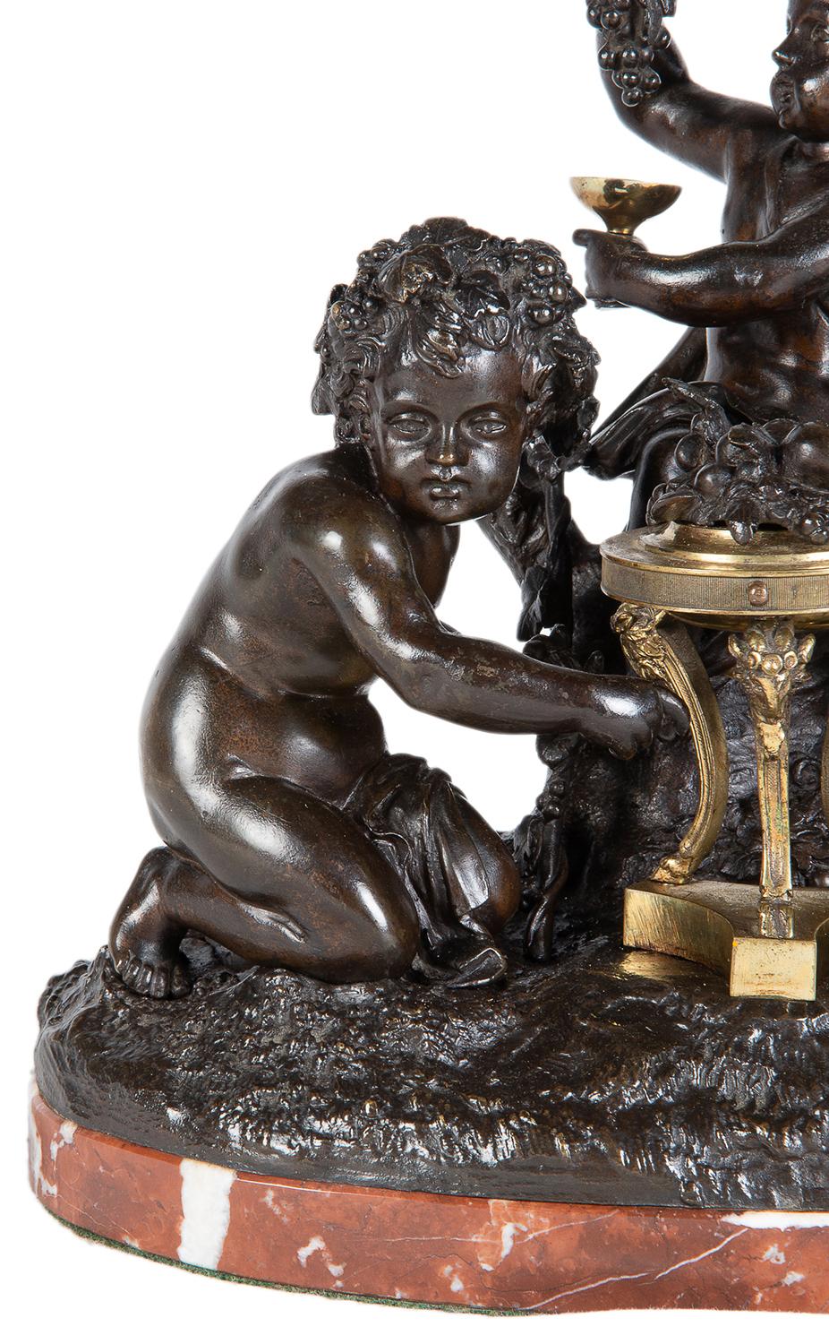 A good quality French 19th century bronze and ormolu group of Bacchus cherubs putti each with bunches of grapes, mounted on a rouge marble base.
