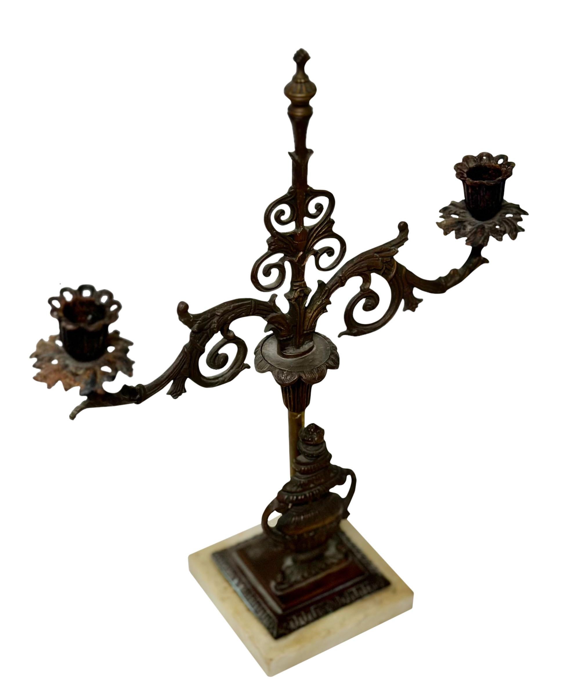 An elegant antique French bronze double arm candlestick with a dark patina and a white marble base. 19th century, France. 