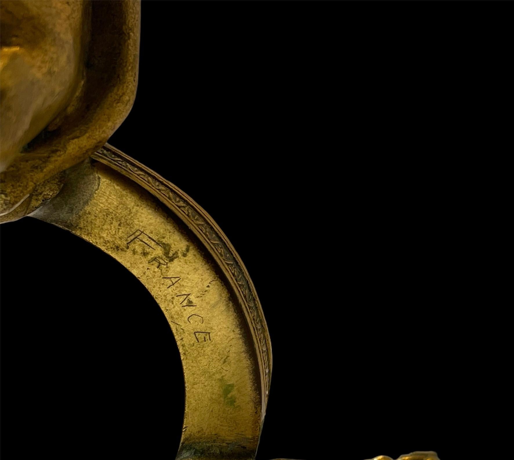 Trio of bronze cherubs forming a circle with their hands backward serve as support for holding a cut crystal bowl. Below the round bronze base is written France.