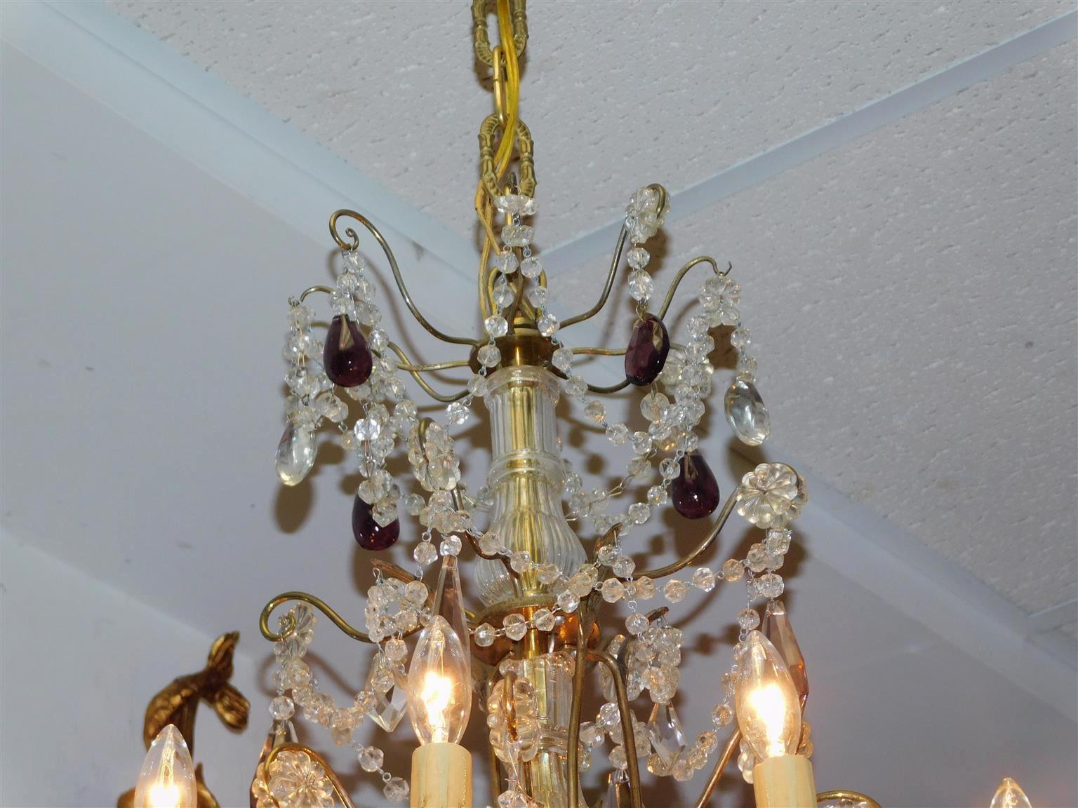 French bronze and crystal eight scrolled arms amethyst prism chandelier with a fluted central bulbous column, floral medallions, and crystal ball finial. Chandelier was originally candle powered and has been electrified. Mid-19th century.