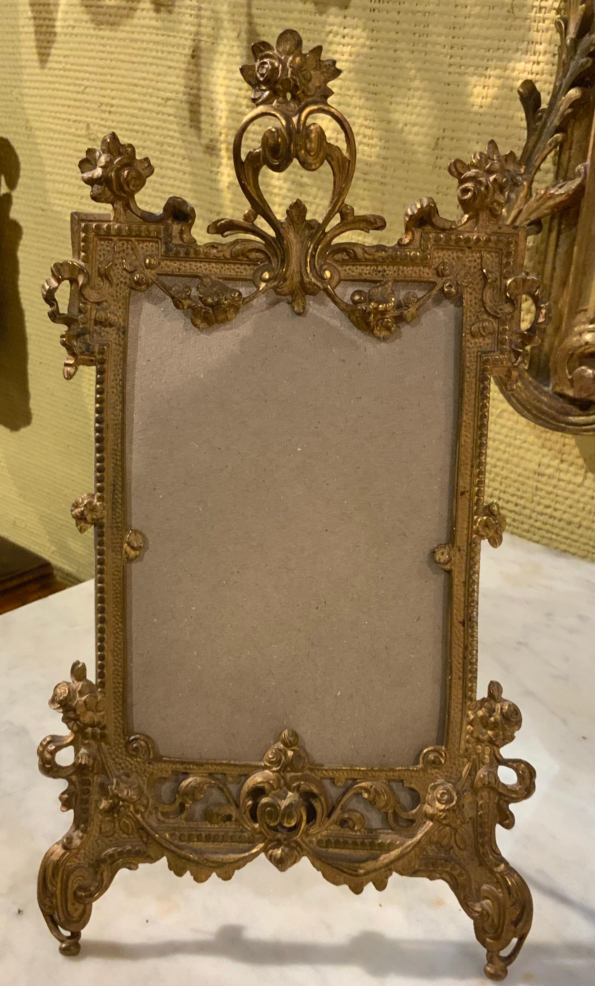 Exquisite bronze dore French desk top frame with an
Easel back to support the frame. The gilding is original
In a beautiful antique patina. Rococo in style with many
Curves and flourishes with a floral and foliate motif
Throughout. An oval heart