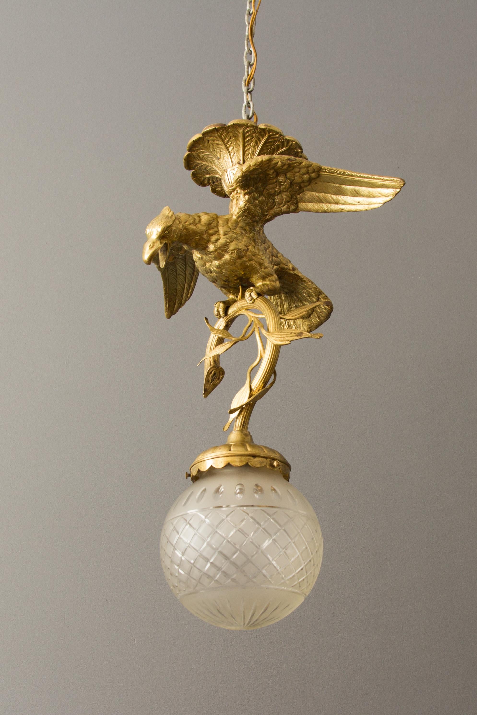 Beautiful massive bronze chandelier from the 1920s - eagle holding a branch - a fixture for the frosted glass lamp shade. The pendant has one socket for the E27 size light bulb.
Measures: Height is 20.4 inches / 52 cm; diameter - 14.5 inches / 37 cm.