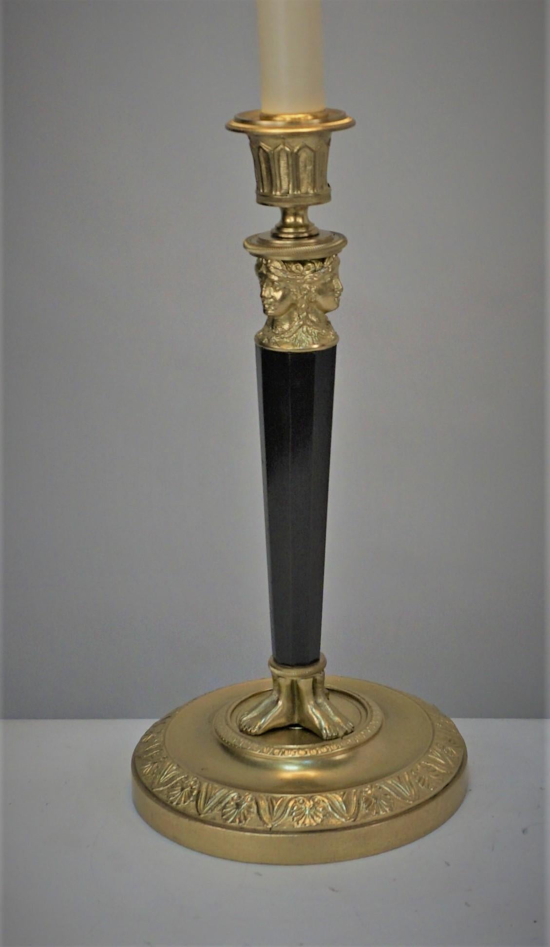 Empire two color bronze candlestick that has-been electrified as table lamp with small silk lampshade.