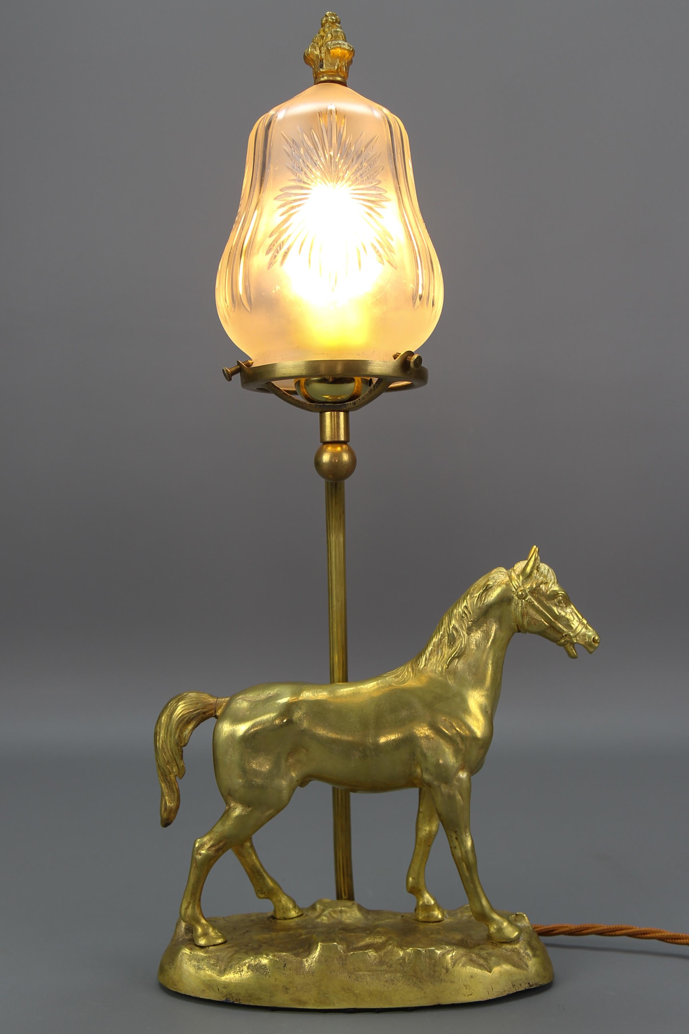 French bronze and cut frosted glass table lamp with a horse, from circa the 1950s.
A beautiful and heavy French bronze table lamp with a horse figure from the middle of the 20th century. This stunning Hollywood Regency-style table lamp features an