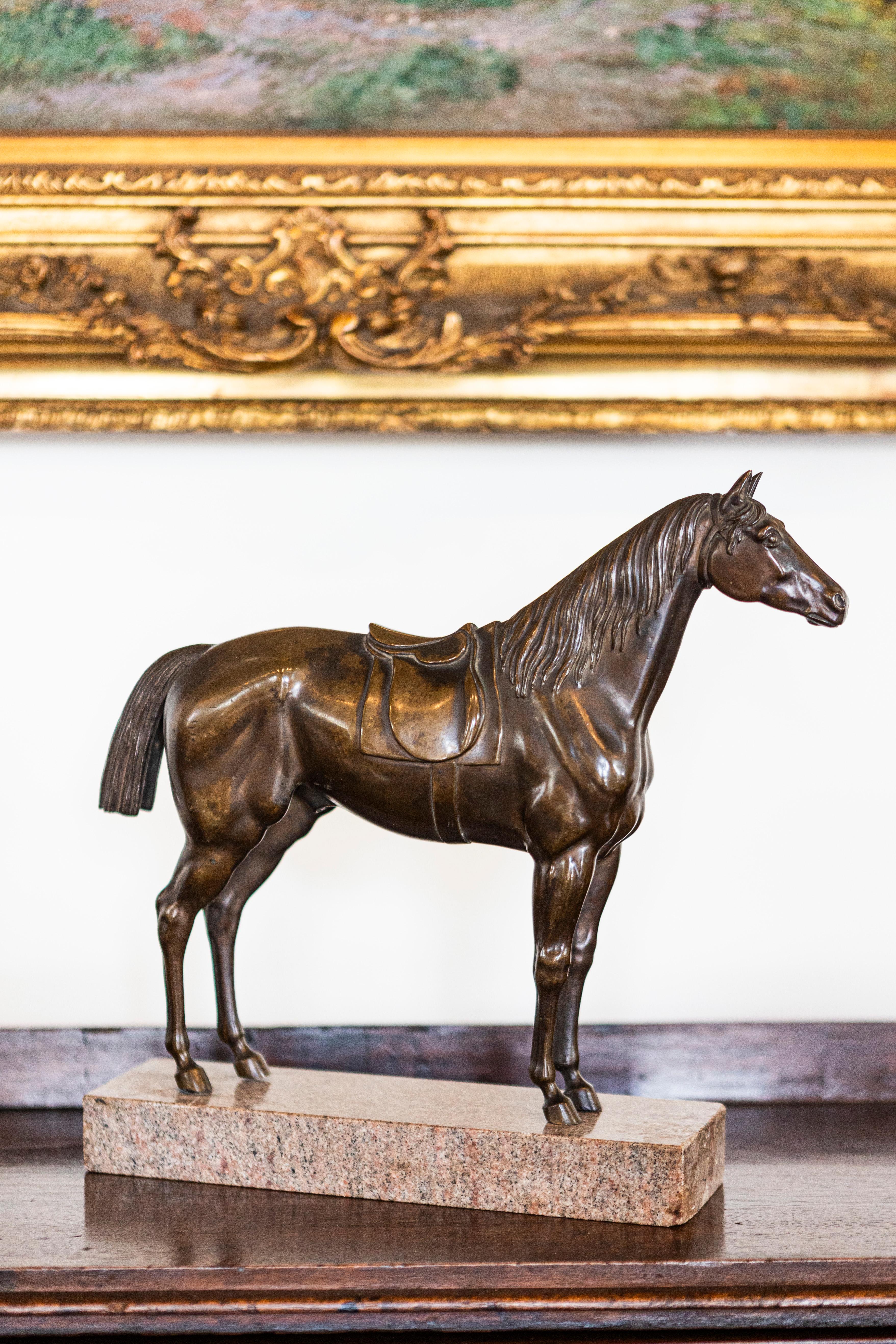 This exquisite French bronze horse statuette from the 20th century is an undeniable example of fine craftsmanship, prominently displayed on a sophisticated granite base. The statuette captures the majestic spirit of the horse, with its musculature