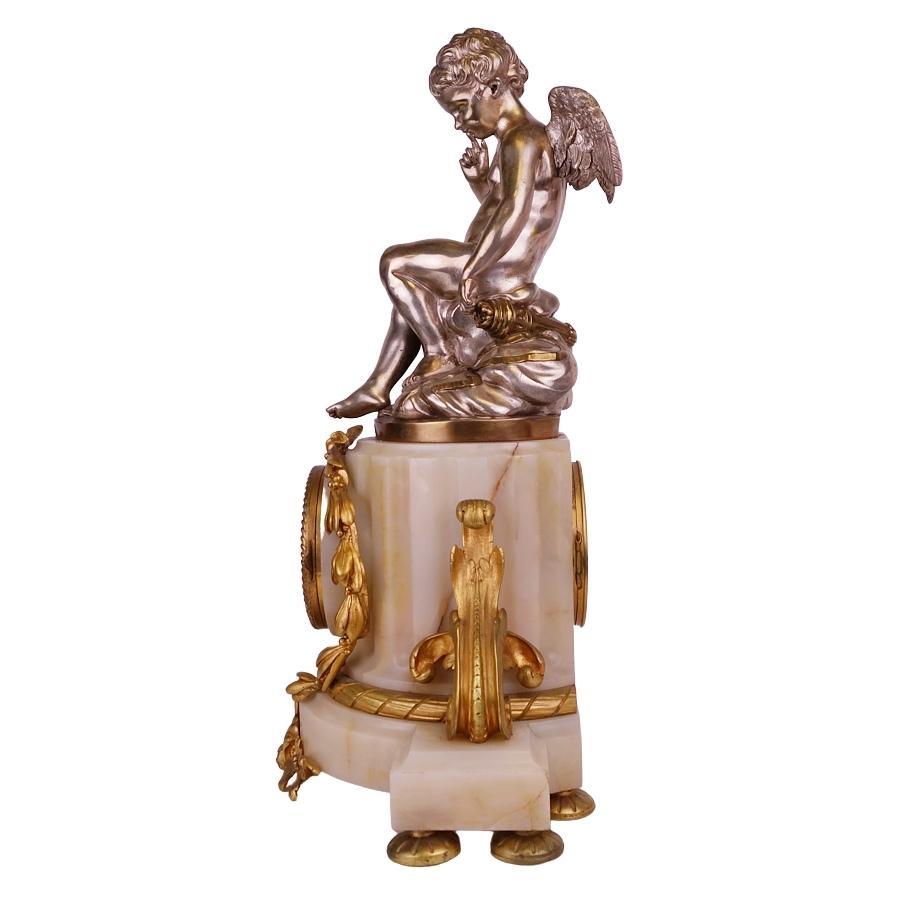 A very fine French, 19th century Louis XV style gilt bronze and white marble figural mantel clock by Lemerie Carpentier Bronzier. The finely chased ormolu body, with its original two-tone mercury gilt bronze is centered with a circular opaline glass
