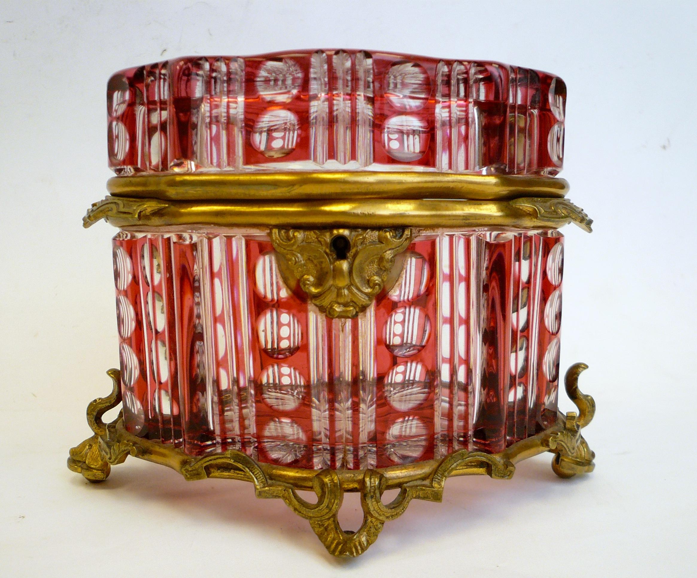 This cased glass {ruby to clear} jewel box, or casket is deeply and elaborately cut.
It is of the finest quality, and retains its original key.