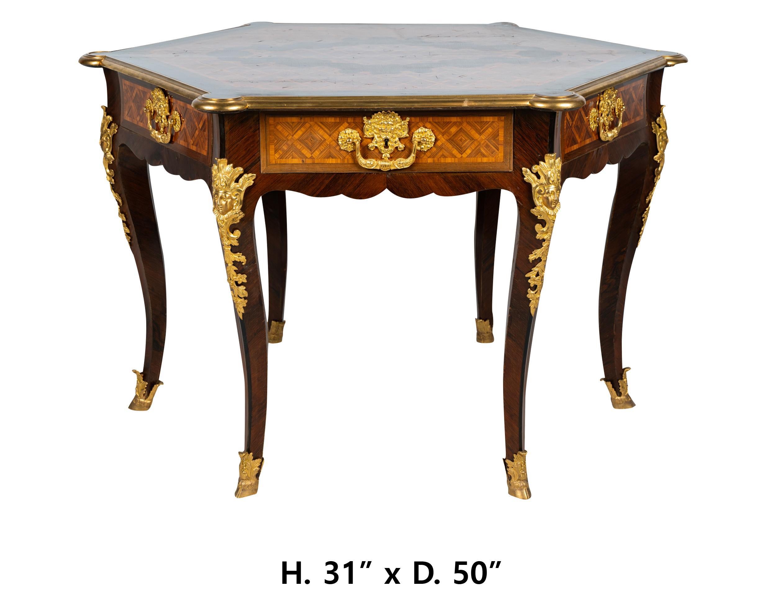 Outstanding French Louis XV style gilt bronze mounted parquetry mounted hexagonal top center table, 1st half of the 20th century.
Meticulous attention has been given to every detail 
the hexagonal inlaid top over six drawers raised on six