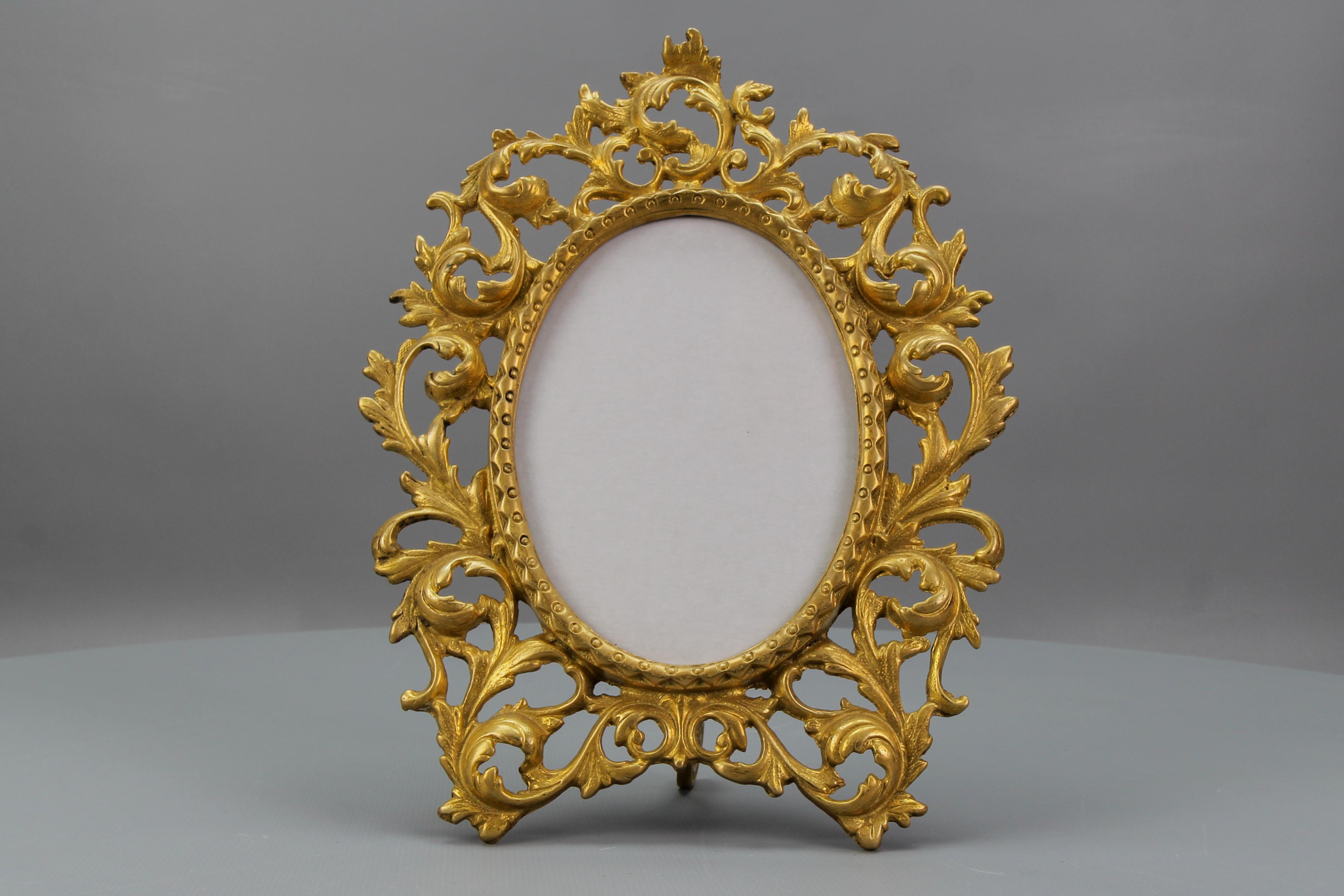 French Bronze Neoclassical Style Oval Desktop Picture Frame from circa the end of the 1930s.
This beautiful ornate oval frame is made of bronze and has a supporting leg on the back. Decorated with typical Neoclassical or Louis XVI-style foliate