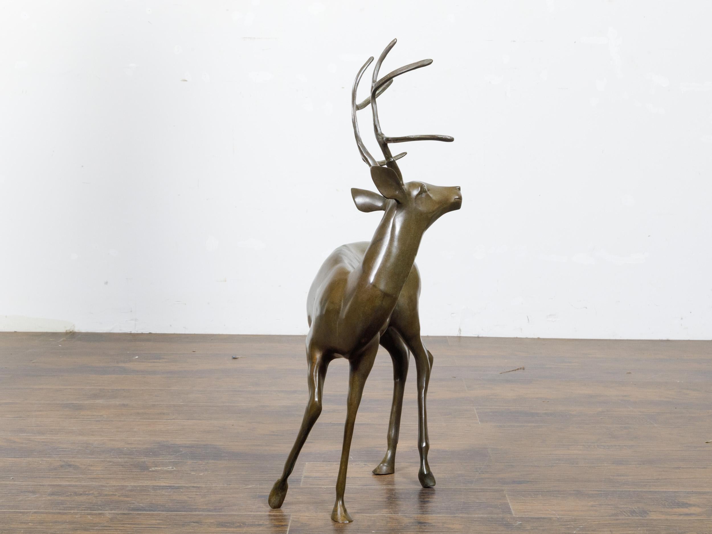 A French bronze sculpture from circa 1970 depicting a stag with large antlers. This exquisite French bronze sculpture from circa 1970 captures the majestic beauty of a stag, rendered with artistic finesse. The stag, portrayed in a poised and elegant