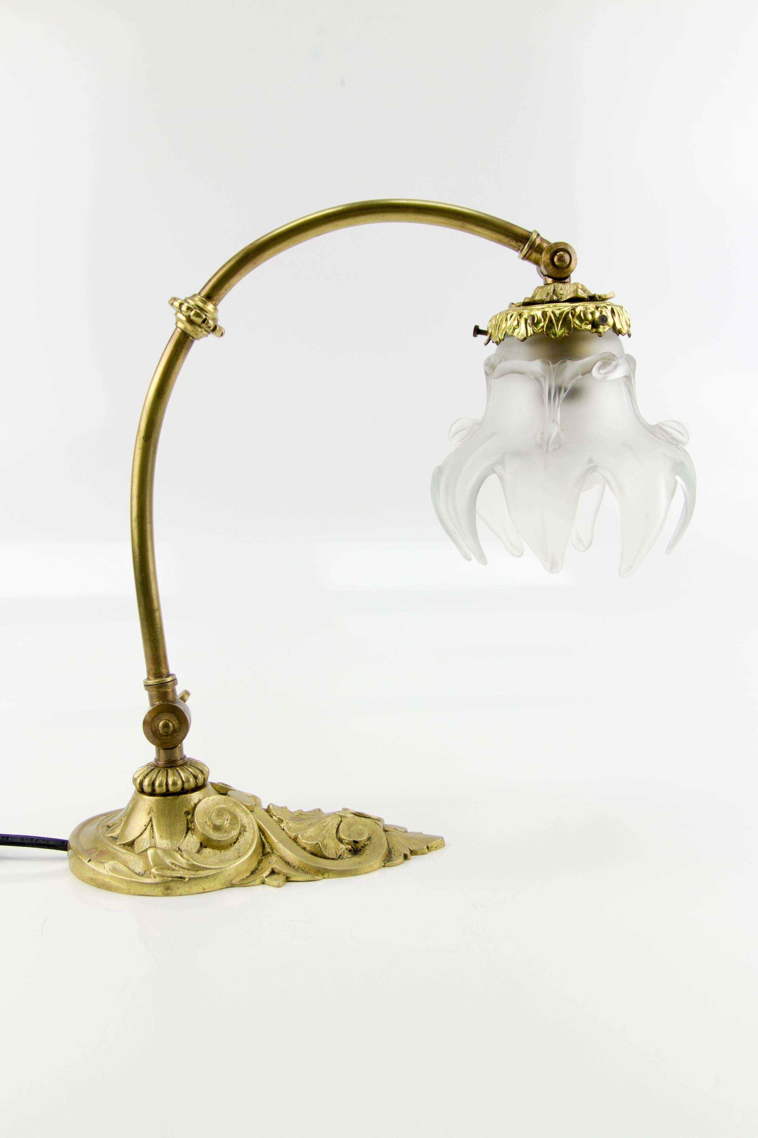 This French Art Nouveau bronze table lamp from the 1930s has a beautifully shaped frosted glass shade and ornate bronze lamp base. The lamp is adjustable in height. Can also be used as a wall lamp. One socket for an E27 (E26) size light bulb. To the