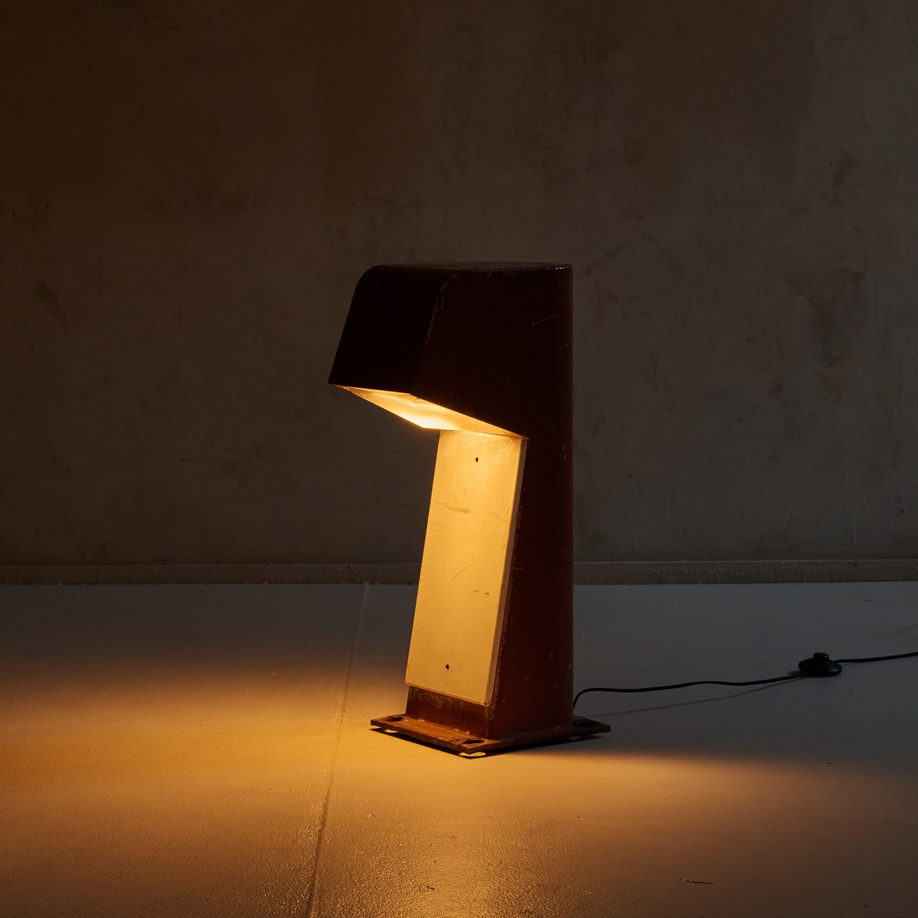 This rare lighting bollard, known as the Blind Bollard (BB), was designed by renowned French architect Jean Balladur in 1969. Crafted from lacquered folded steel, its oblong structure encases a glass diffuser and rests on a square base. The