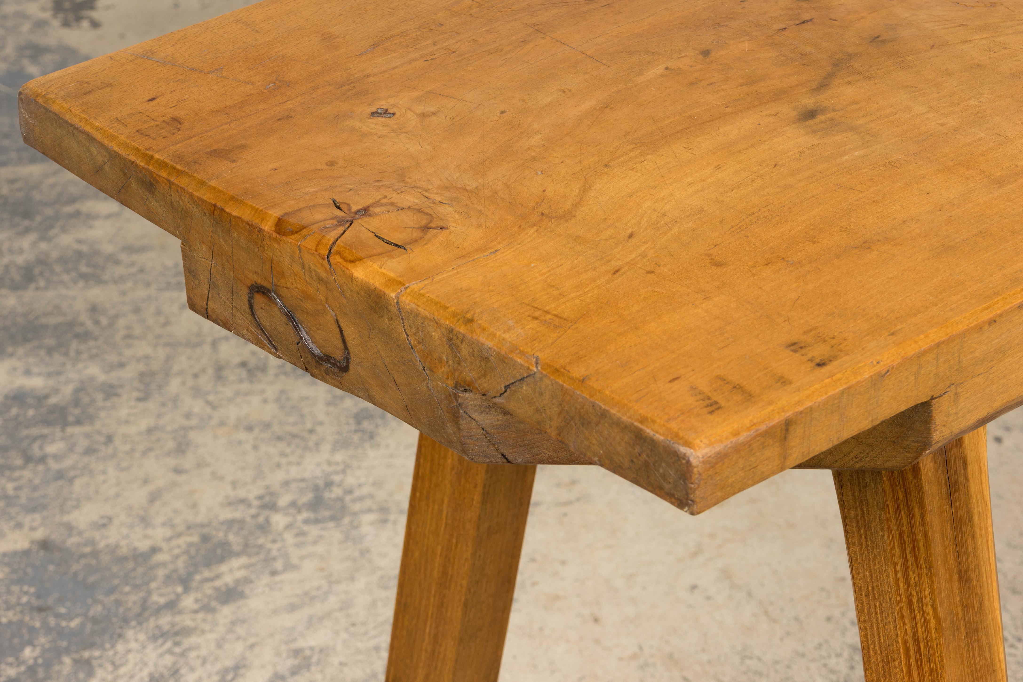 Sculptural mid-20th century French Brutalist butcher block island table. Structurally revised and gently refinished. The thick rectangular top is crafted from a single plank of fruitwood with a raw, tactile surface that reveals prominent knots,