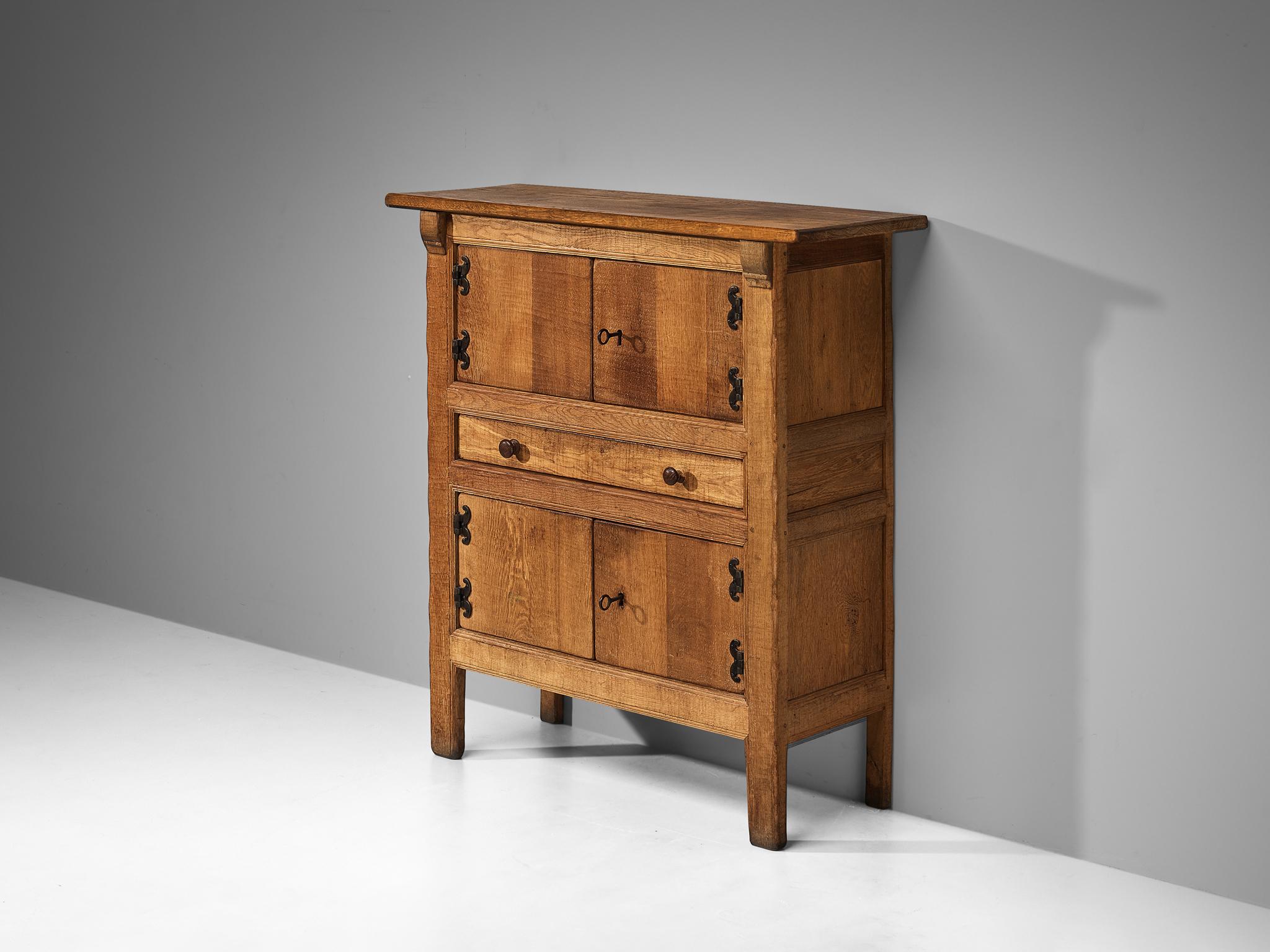 Highboard, oak, iron, France, 1960s

This sideboard is made in France around the 1960s and beautifully reflects the stylistic traits of Brutalism. A solid construction executed in solid oak where clear lines and sturdy shapes are allowed to emerge