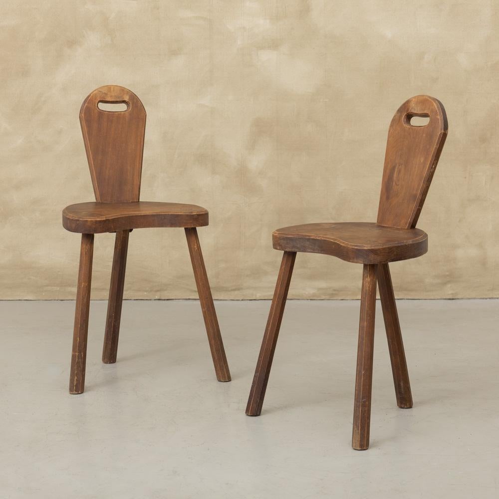 Great carved wood Brutalist tripod chair from France, 1950's. Three thick chiseled wood legs with wide seat and slender wood back. Lovely decorative hole carved on back. Perfect as a side or hall statement chair. Two available, sold individually.