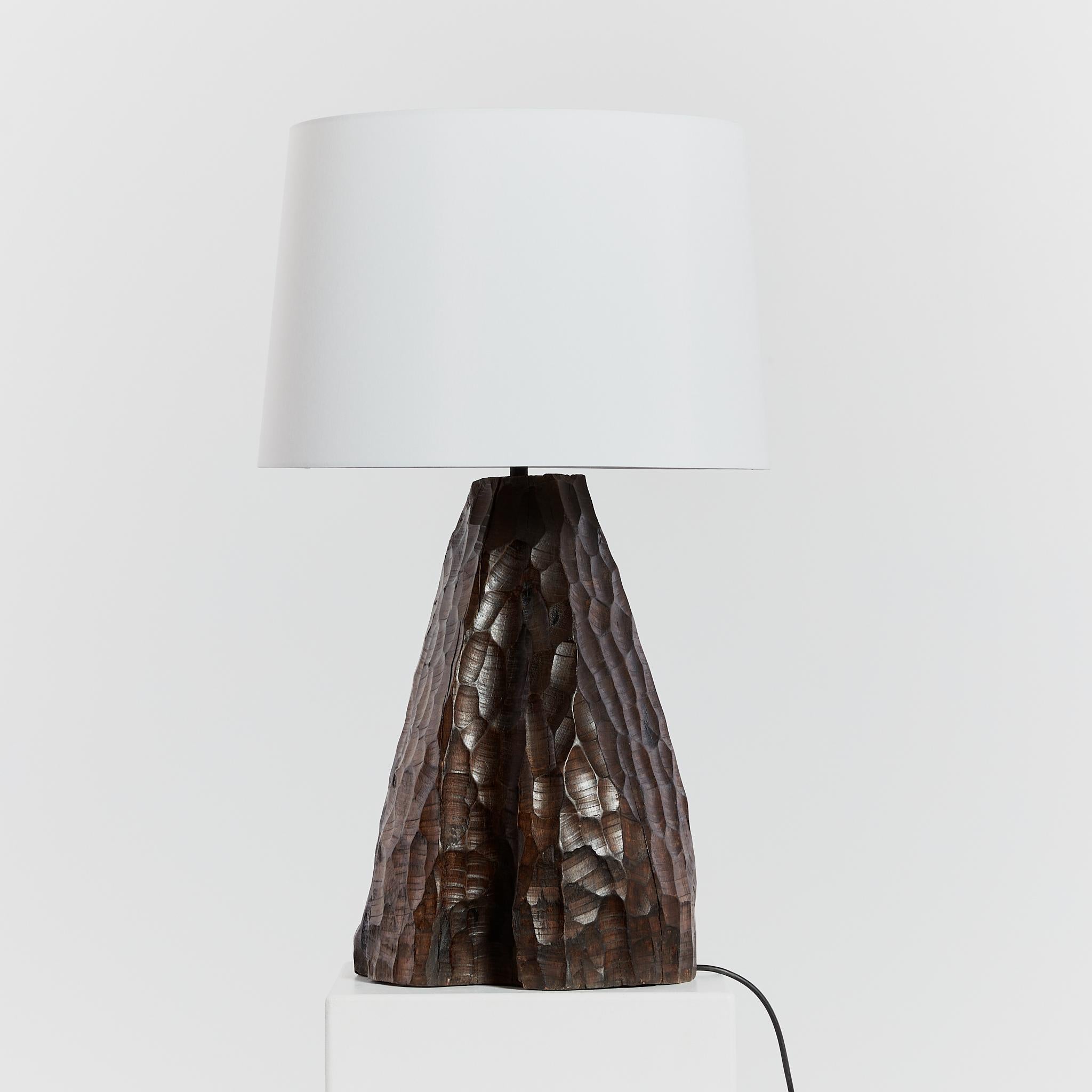 Brutalist wood lamp with oversized chiselled form. The mid-century lamp includes a custom made linen shade in off white.

PAT tested with new UK plug, flex and switch. 

Period: Circa 1970's (base only)

Material: Wood base, silk shade

Dimensions: